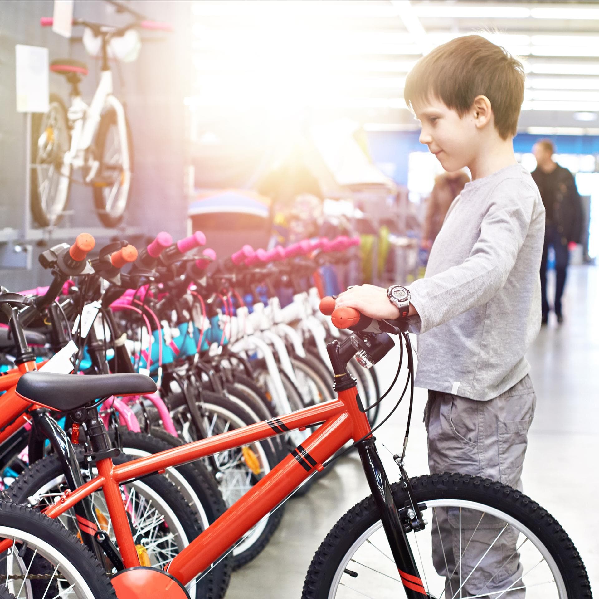 Ein kleiner Junge schaut sich Kinderfahrräder an. 