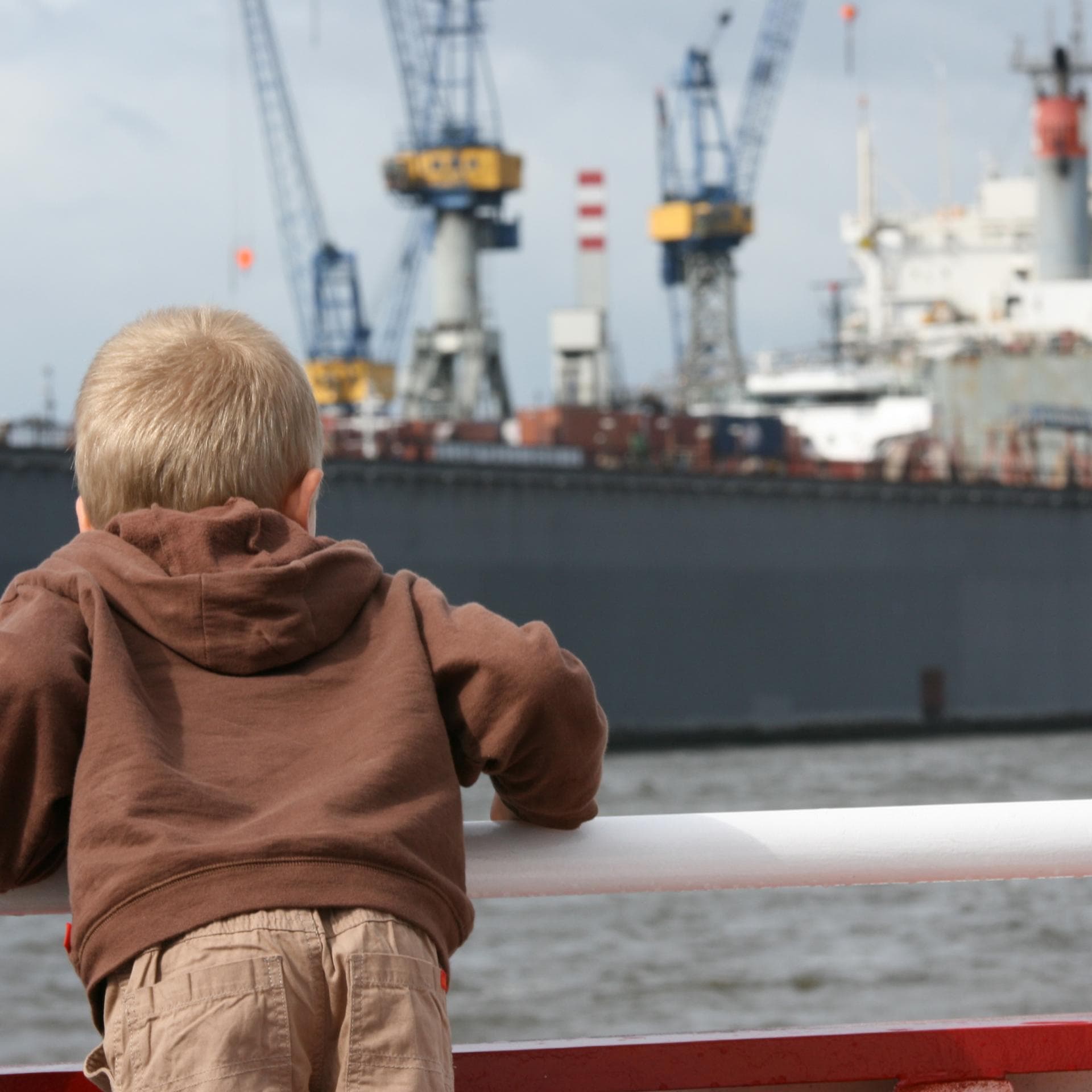 Junge bestaunt Schiff am Hamburger Hafen.