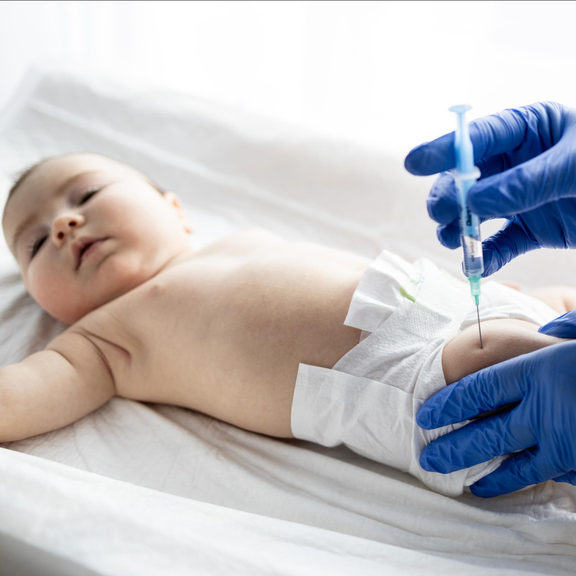 Ein Baby wird in den Oberschenkel geimpft.