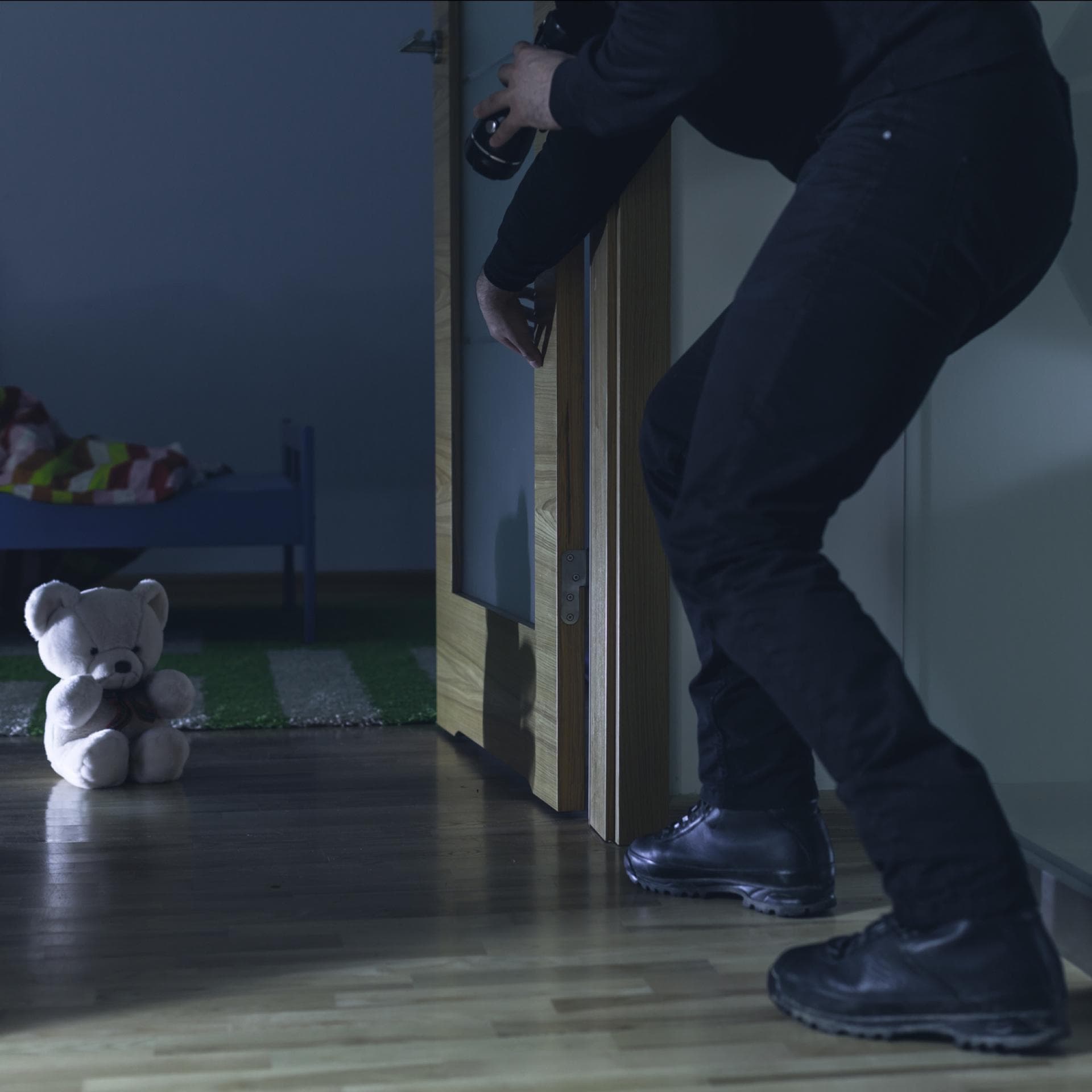 Einbrecher schleicht sich ins Kinderzimmer.