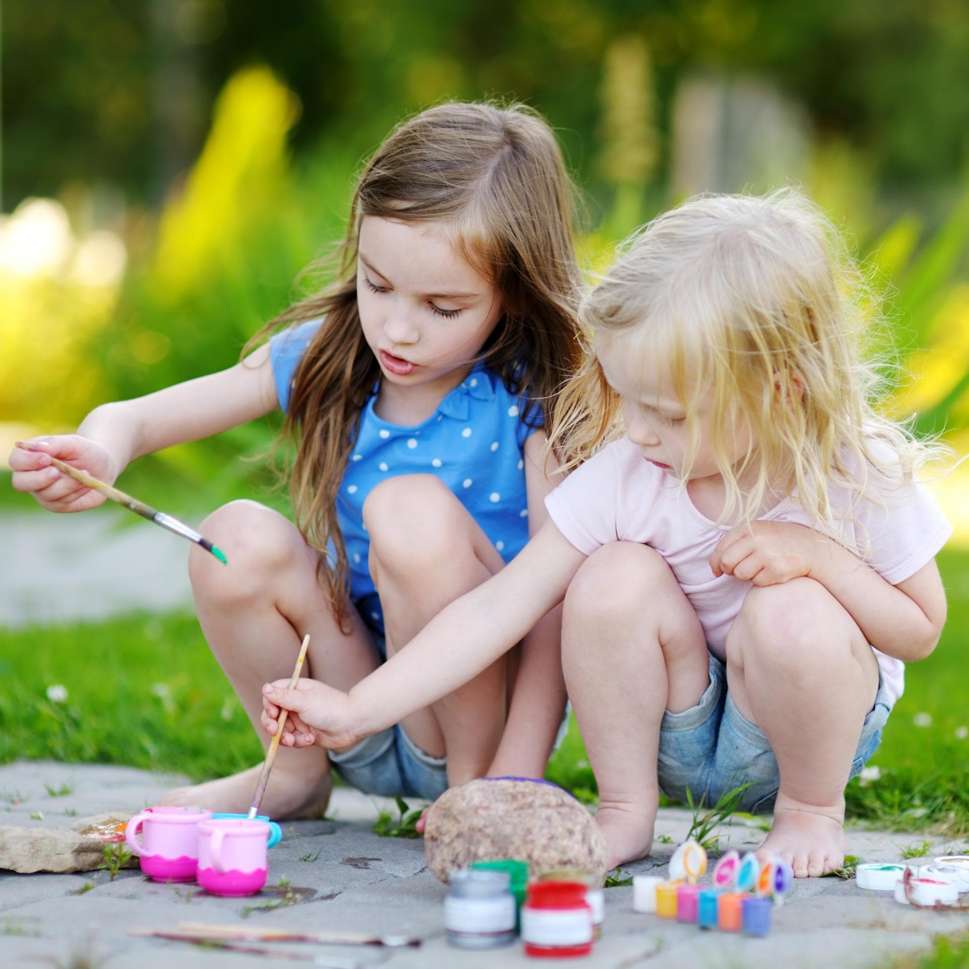 Kleine Mädchen basteln mit Steinen 