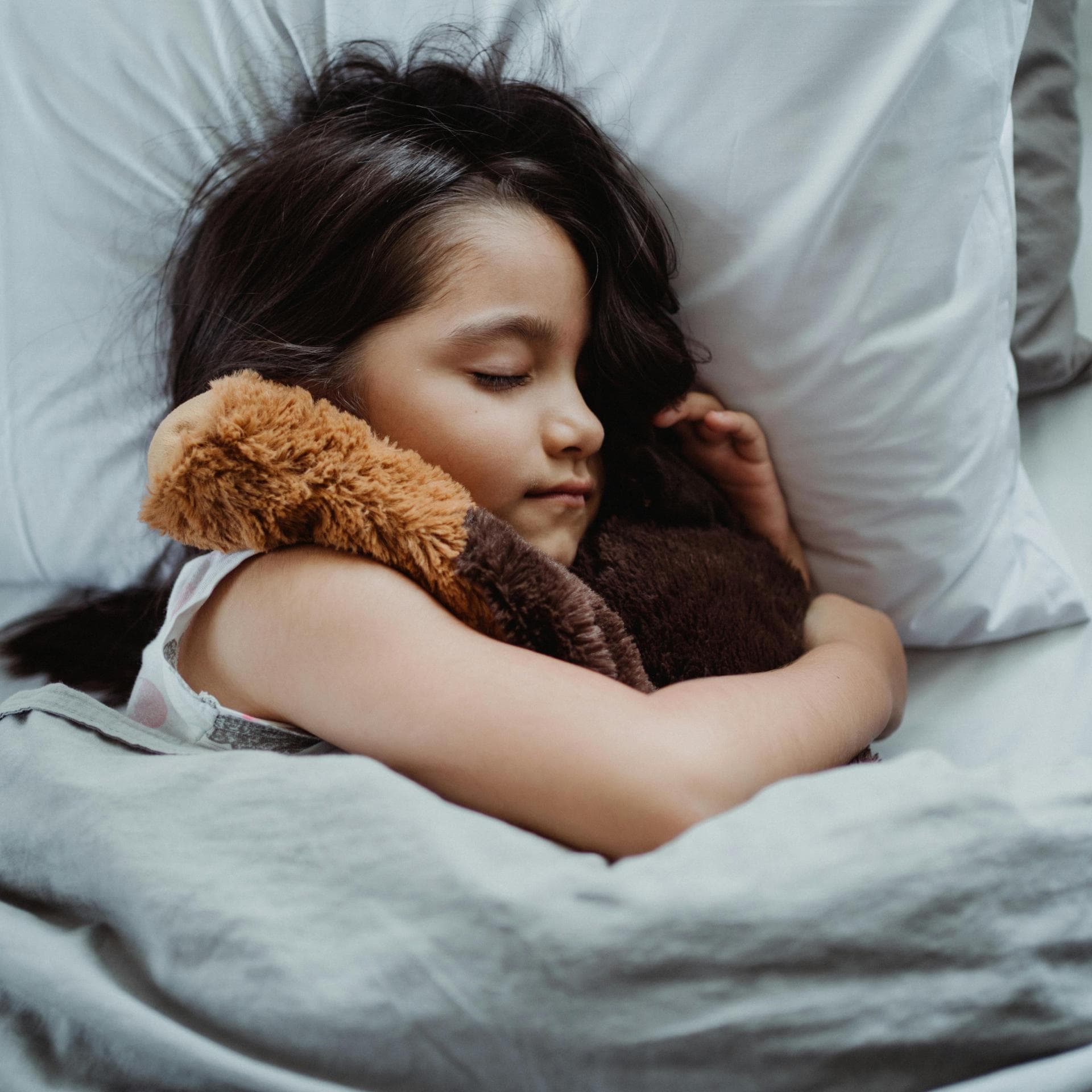 Ein Mädchen liegt schlafend in ihrem Bett.