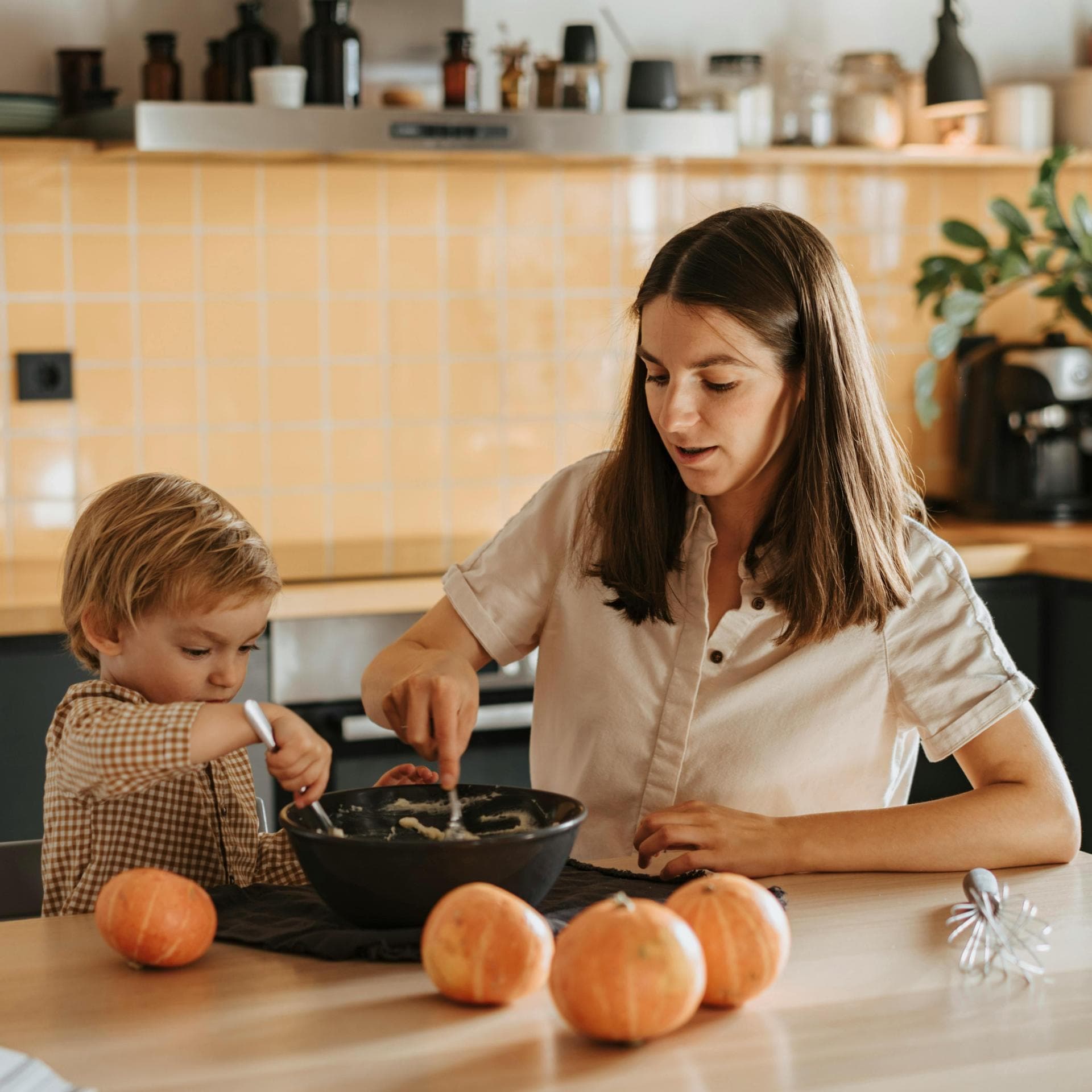 Eine Mutter kocht zusammen mit ihrem kleinen Sohn.