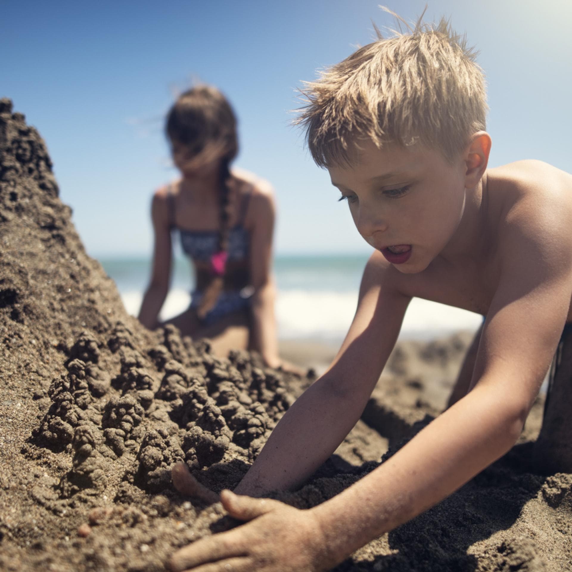 Kinder buddeln am Strand.