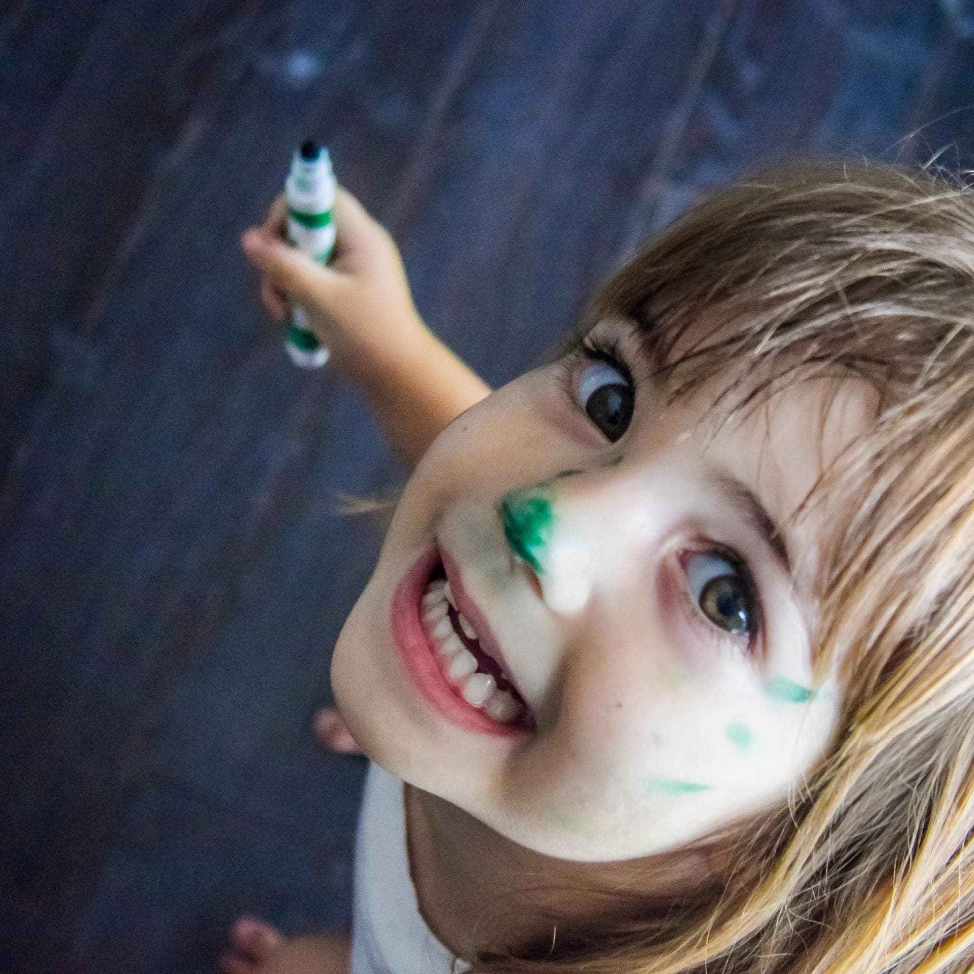 Lachendes Mädchen mit Stift in der Hand.
