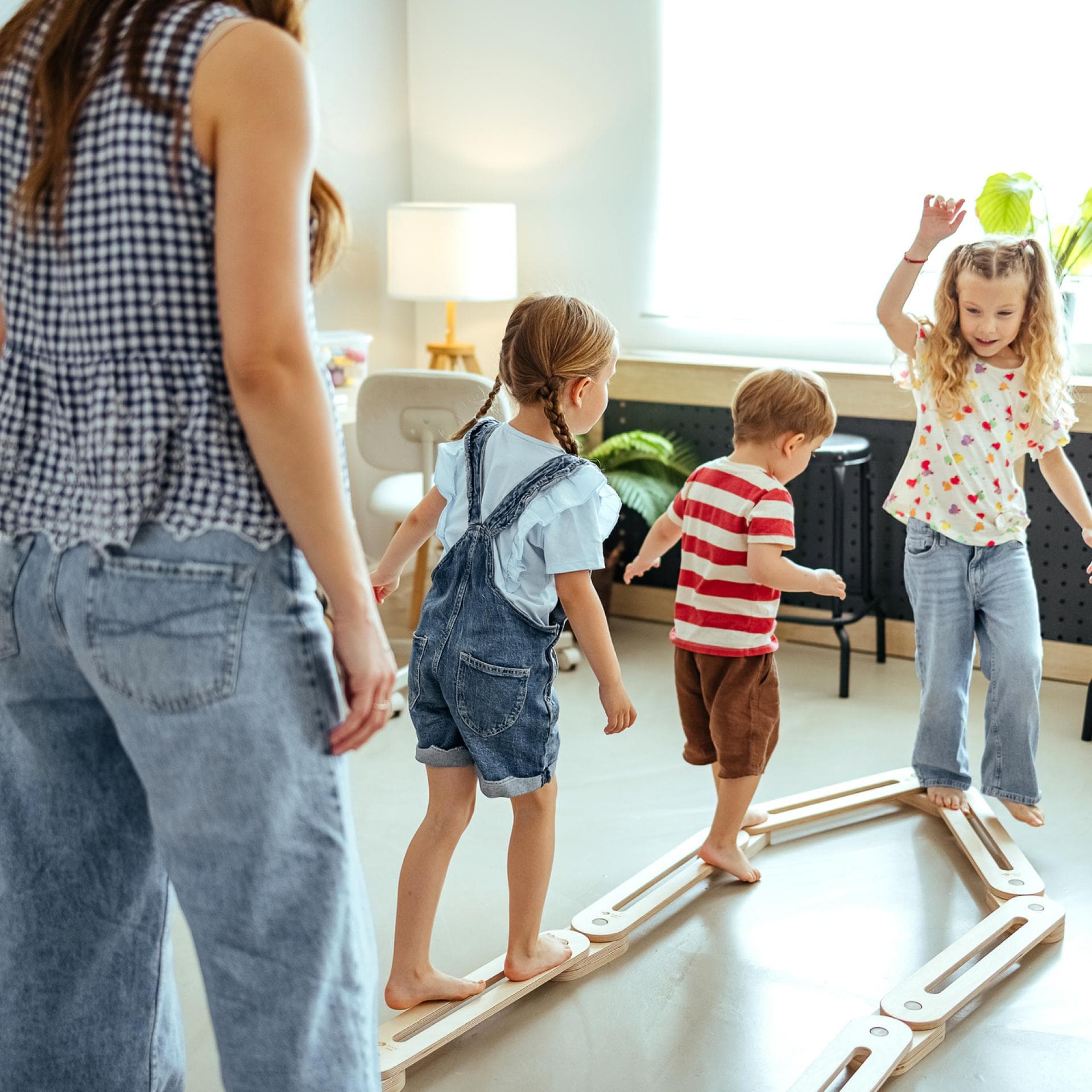 Drei Kinder spielen mit einer Frau.