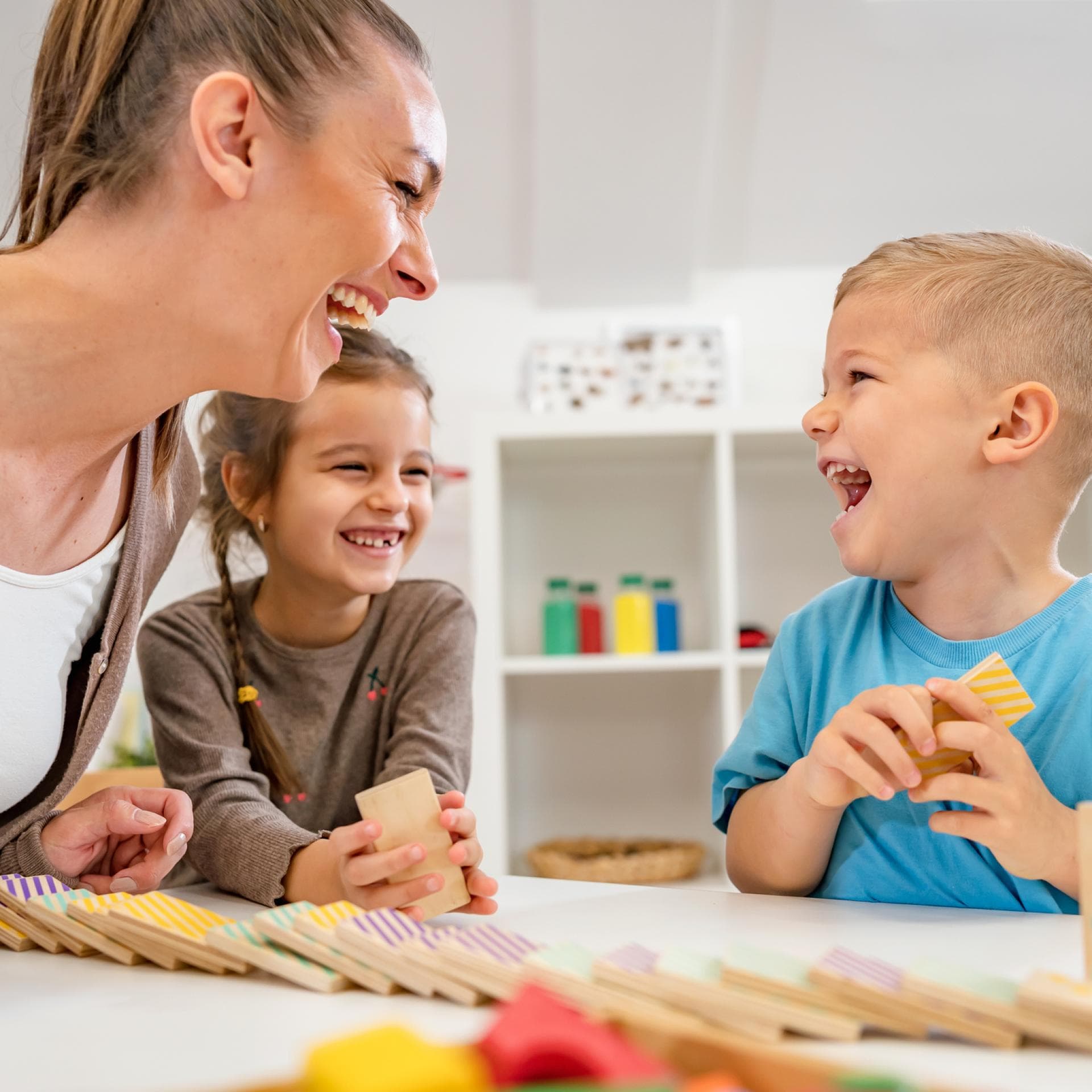 Eine Erzieherin, die mit einem Kind gemeinsam lacht
