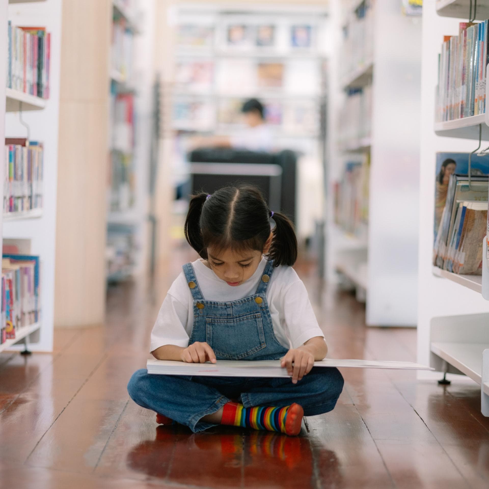 Mädchen liest in Kinderbuchhandlung.