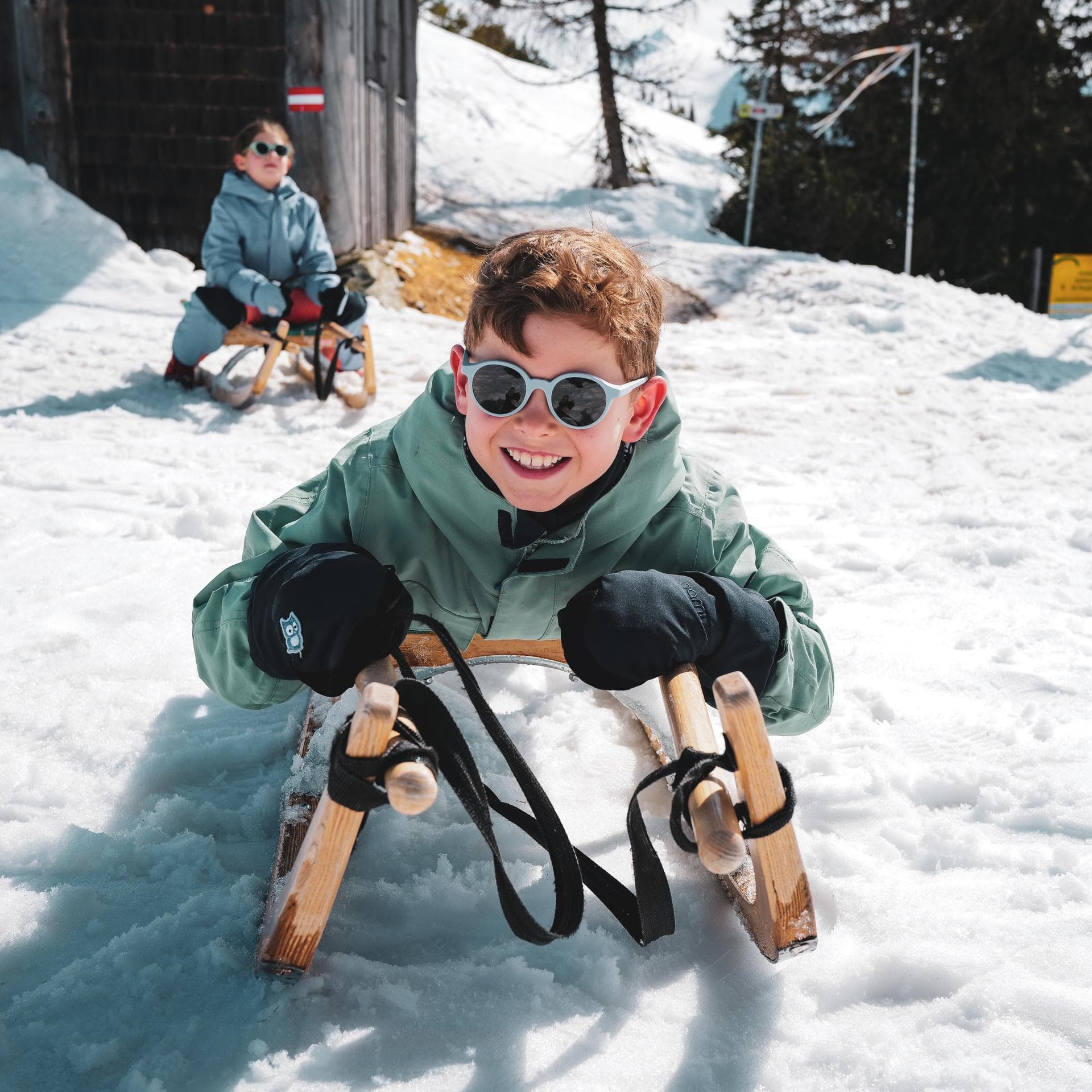 Ein kleiner Junge auf dem Schlitten
