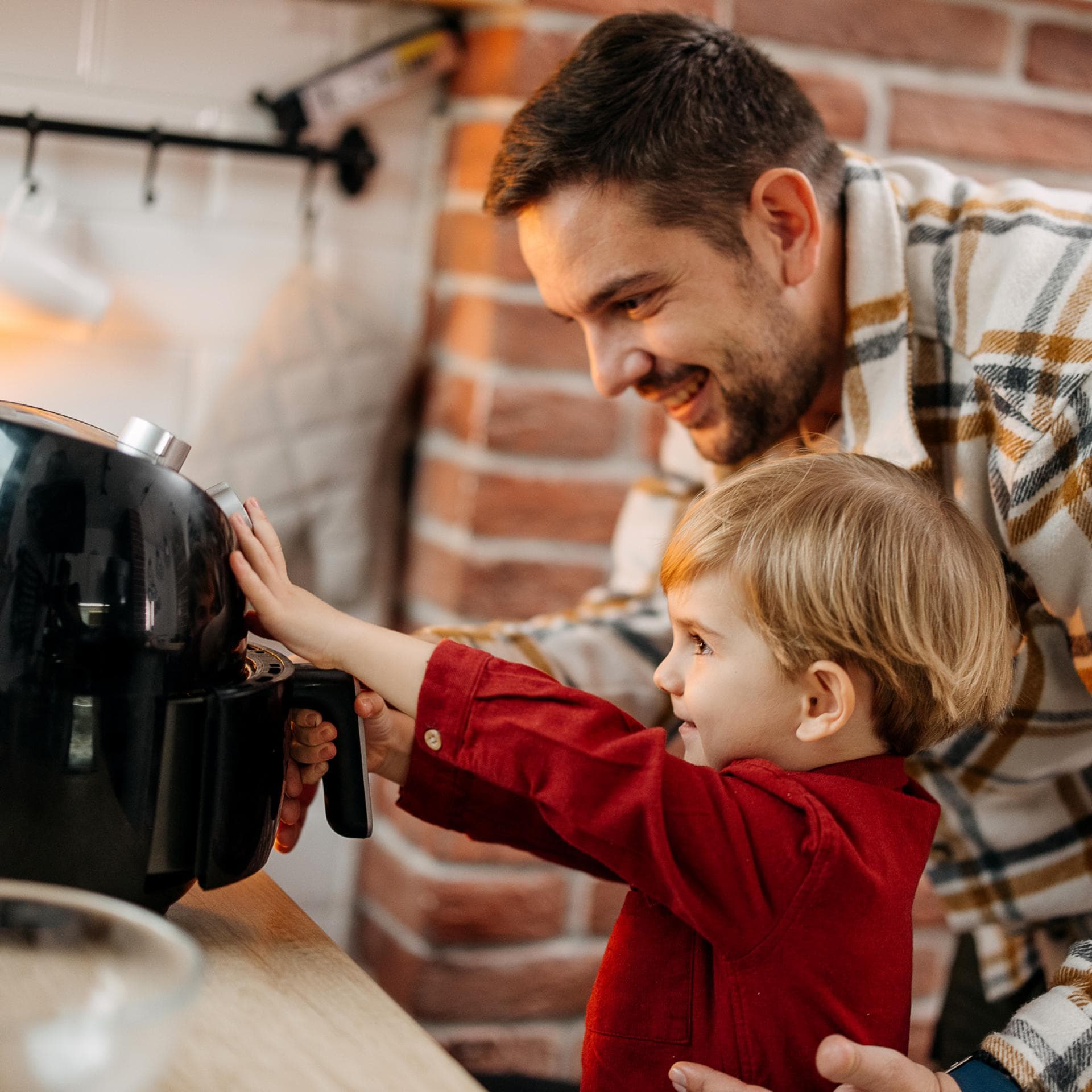 Ein Vater mit Sohn an der Heißluftfritteuse