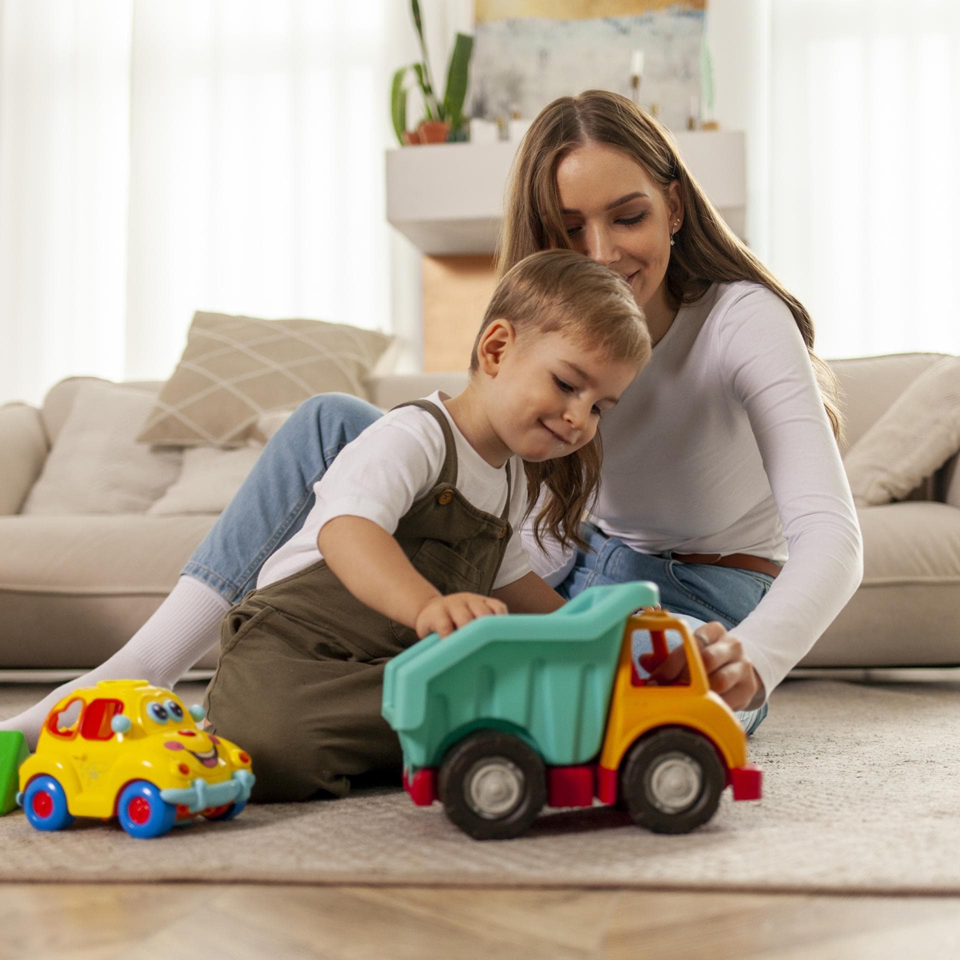 Mutter spielt mit ihrem Sohn auf dem Fußboden.