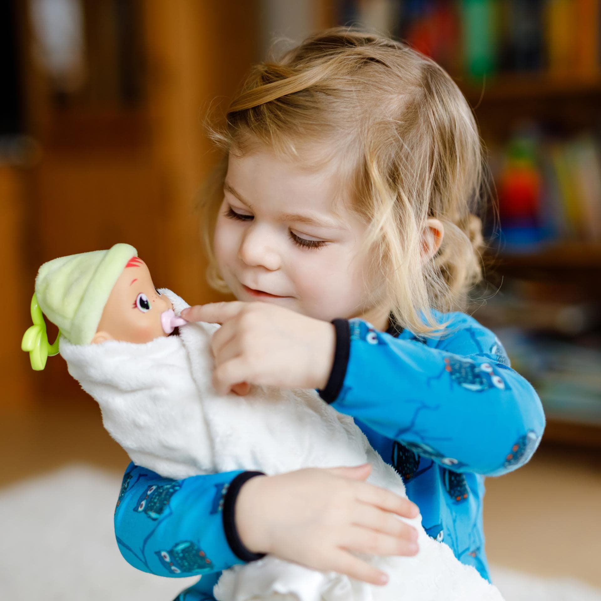 Ein Mädchen spielt mit einer Puppe. 