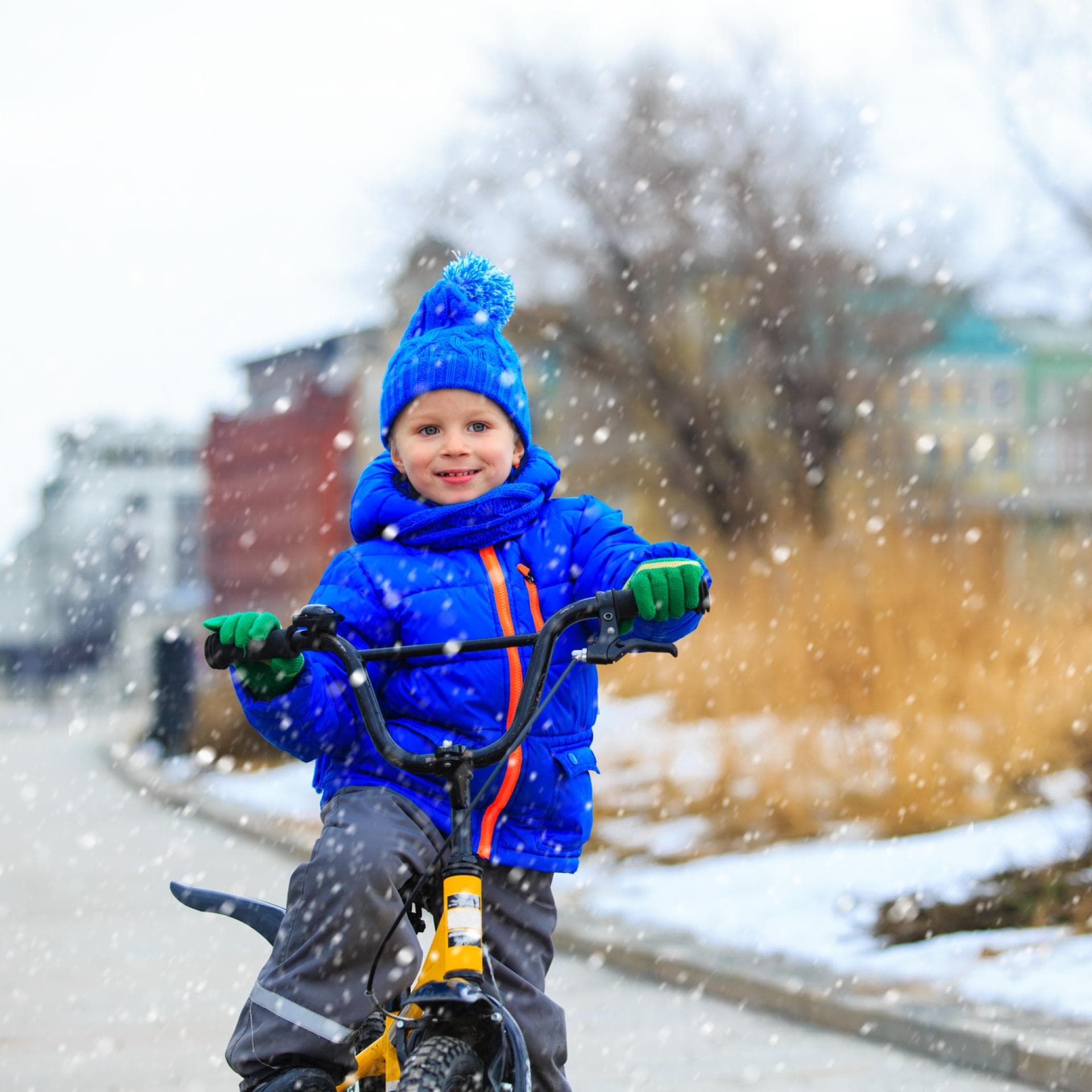 Kind fährt im Schnee Fahrrad.