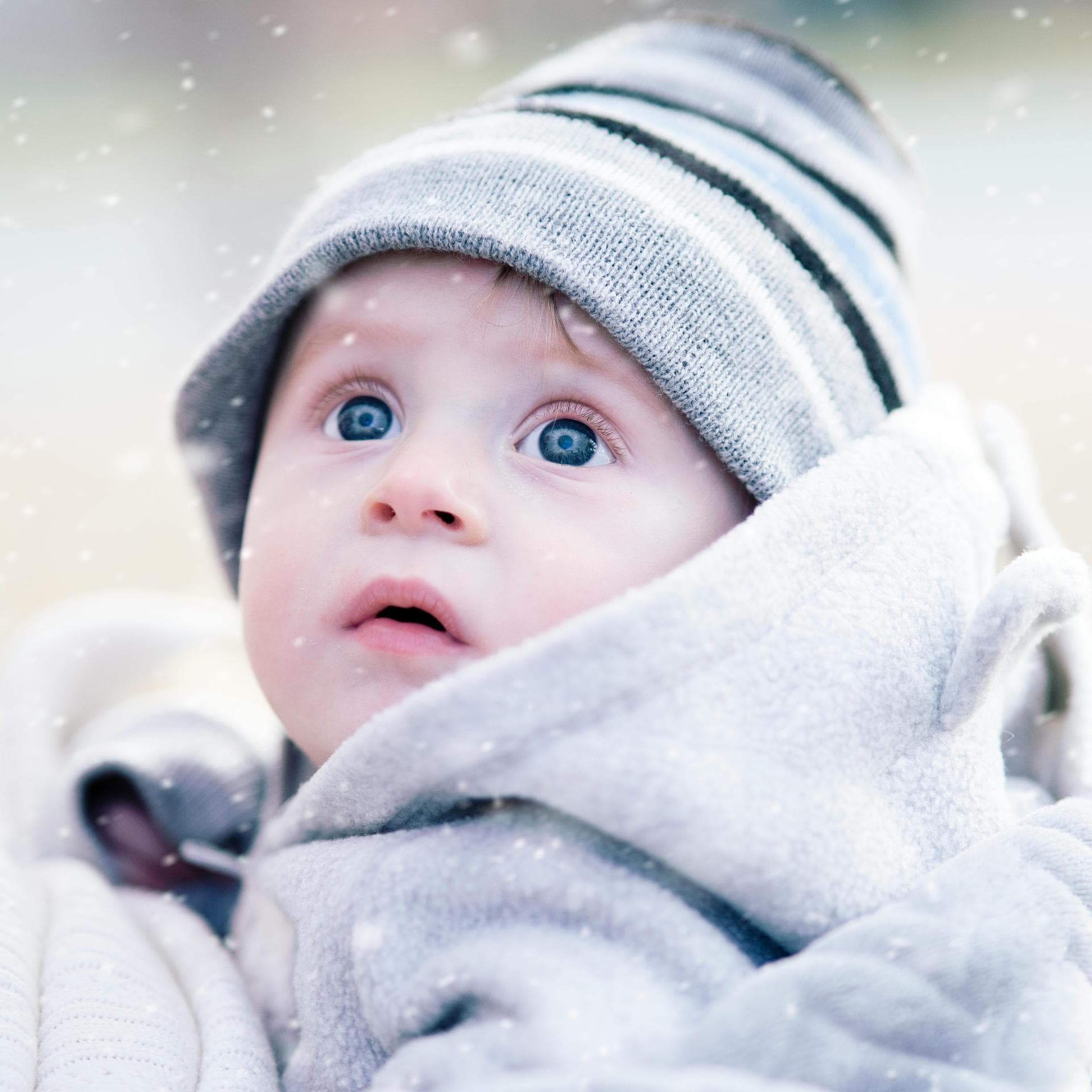 Kleiner Junge staunt über Schneeflocken.