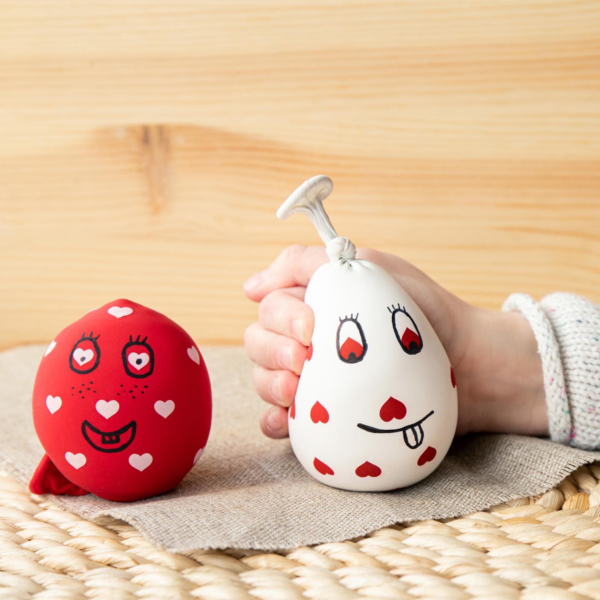Kinderhand und zwei selbst gemachte Stressbälle.
