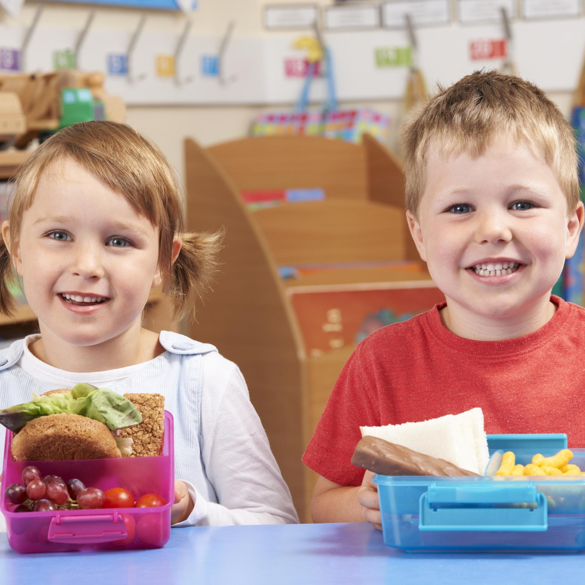 Zwei Kinder mit unterschiedlichen Brotdosen.