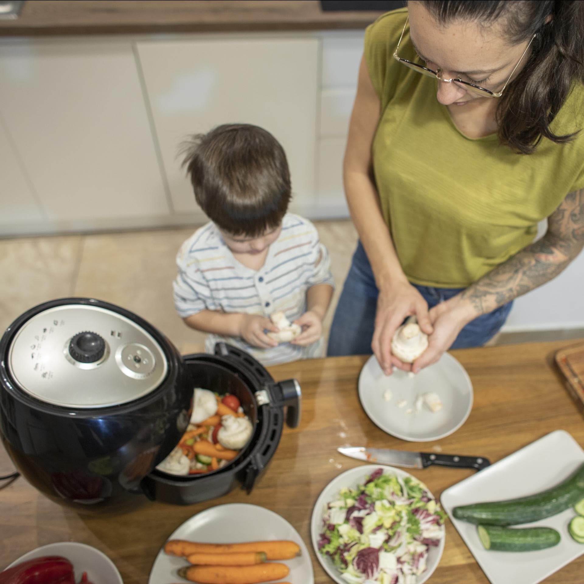 Mutter und Kind kochen mit dem Airfryer.