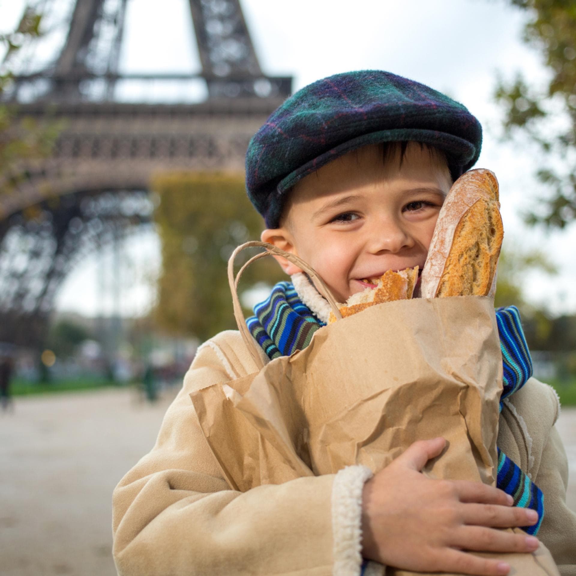 Ein Kind in Frankreich mit Baguettes in der Hand