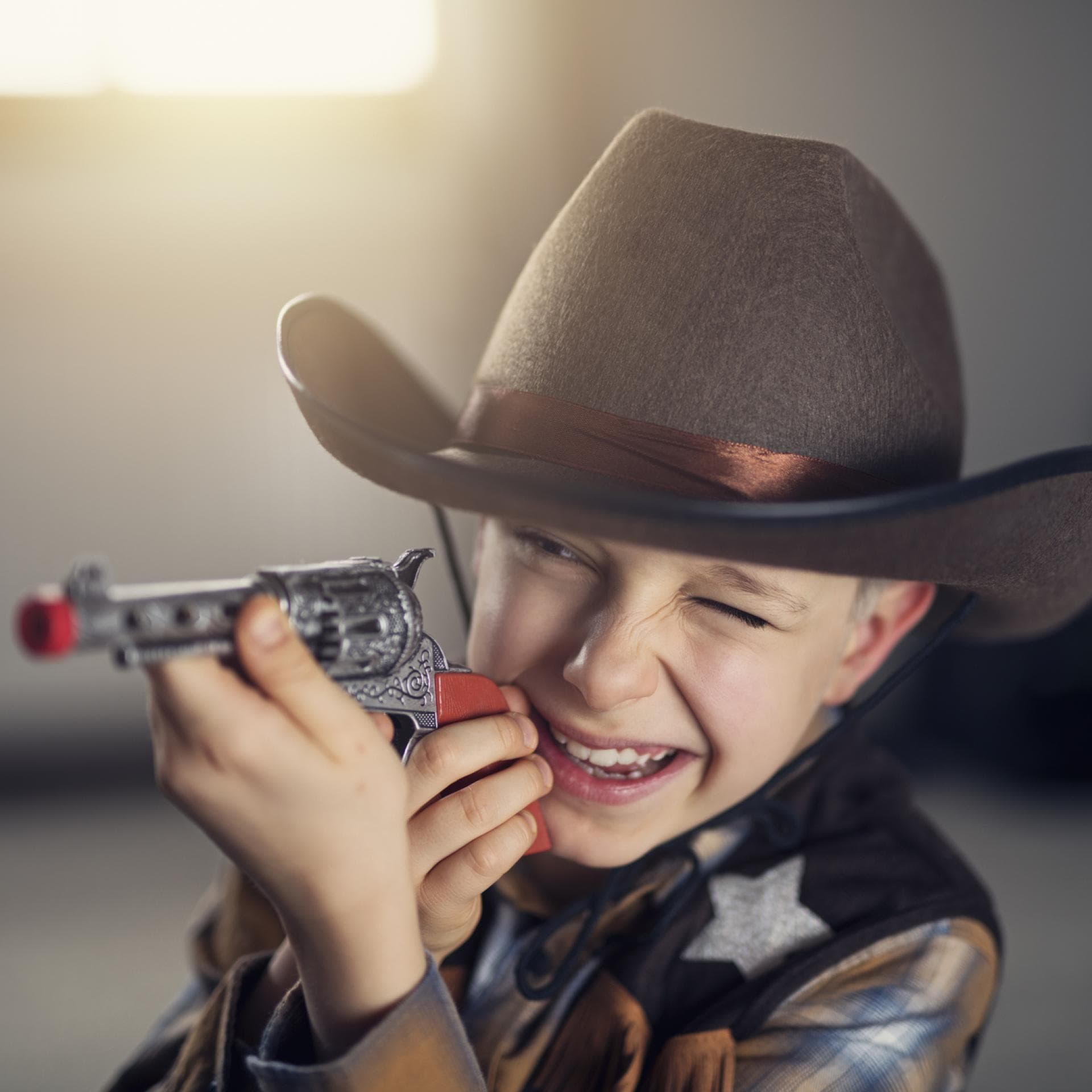 Ein Junge als Cowboy mit Spielzeugpistole