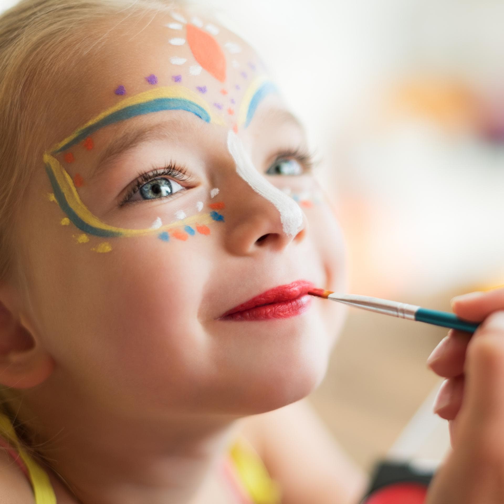 Zauberhaftes Mädchen, das für Karneval geschminkt wird.