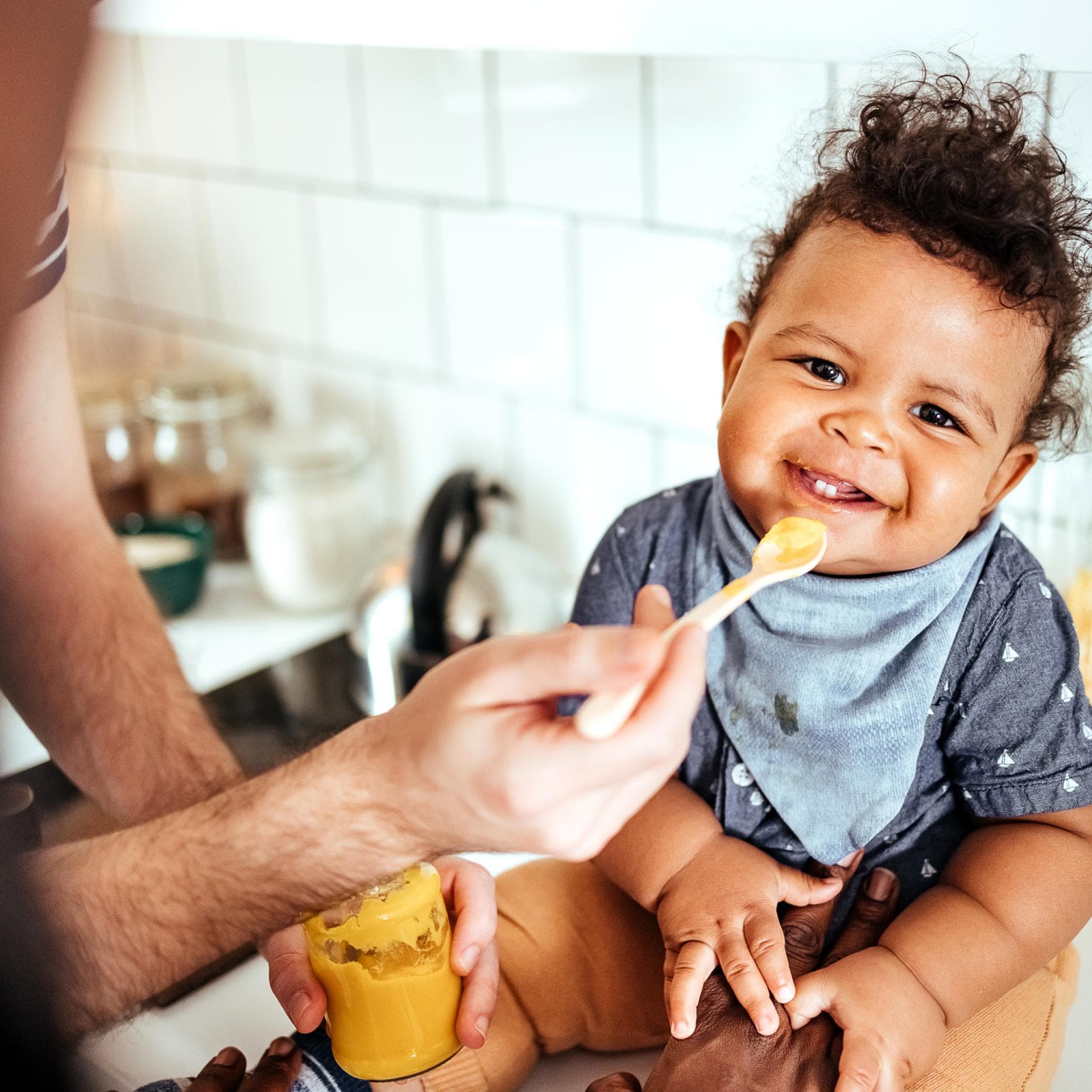 Vater füttert Kind mit Brei.
