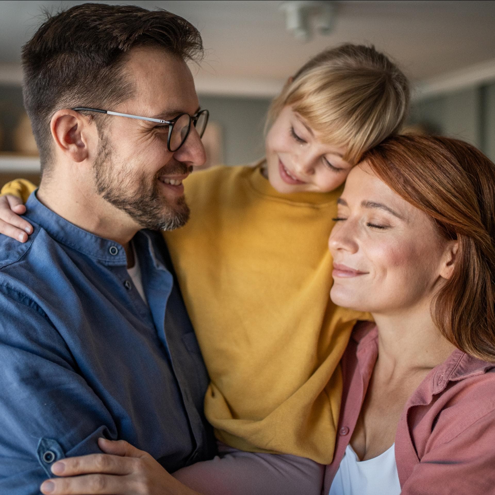 Familie nimmt sich zu dritt in den Arm.