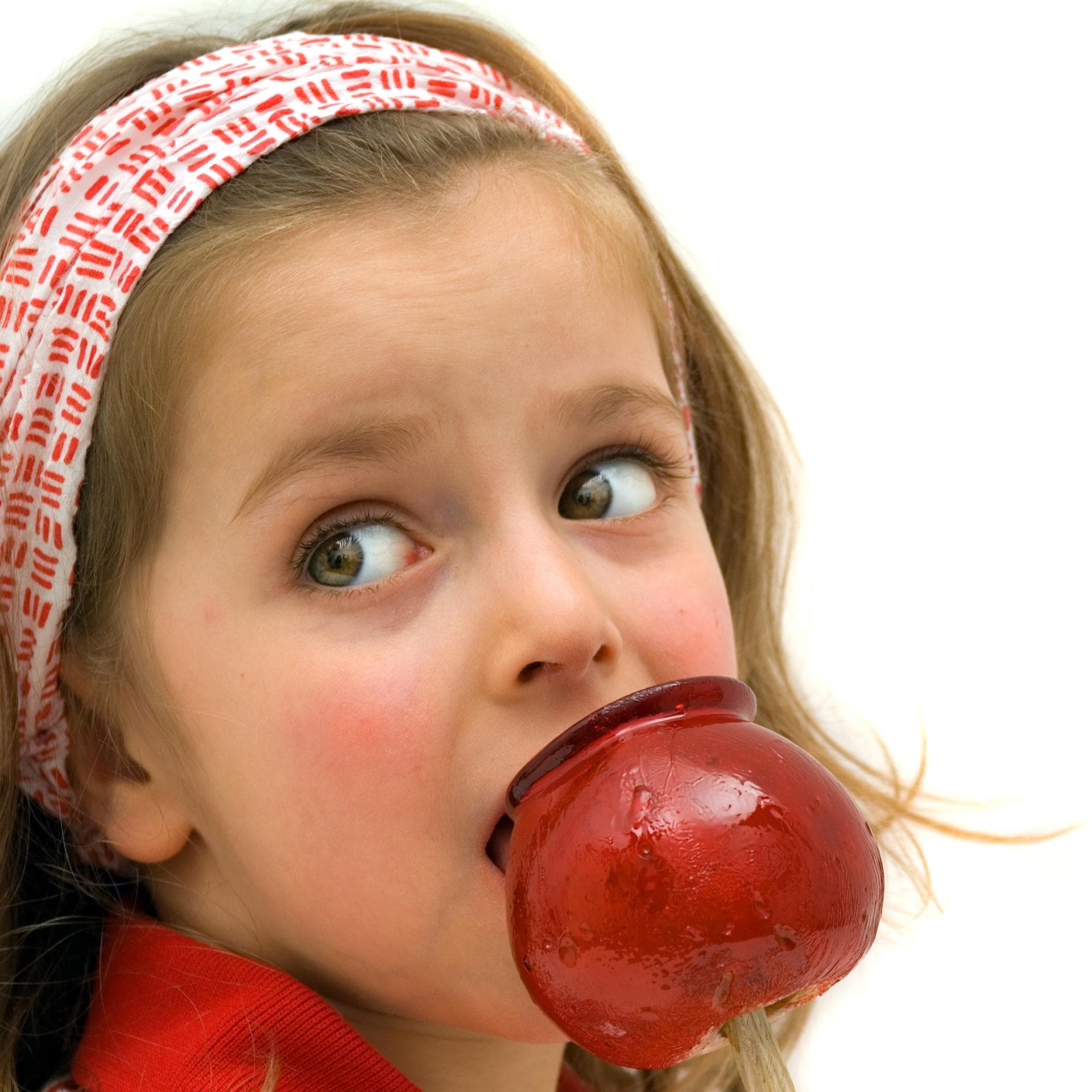 Ein kleines Mädchen beißt in einen Liebesapfel