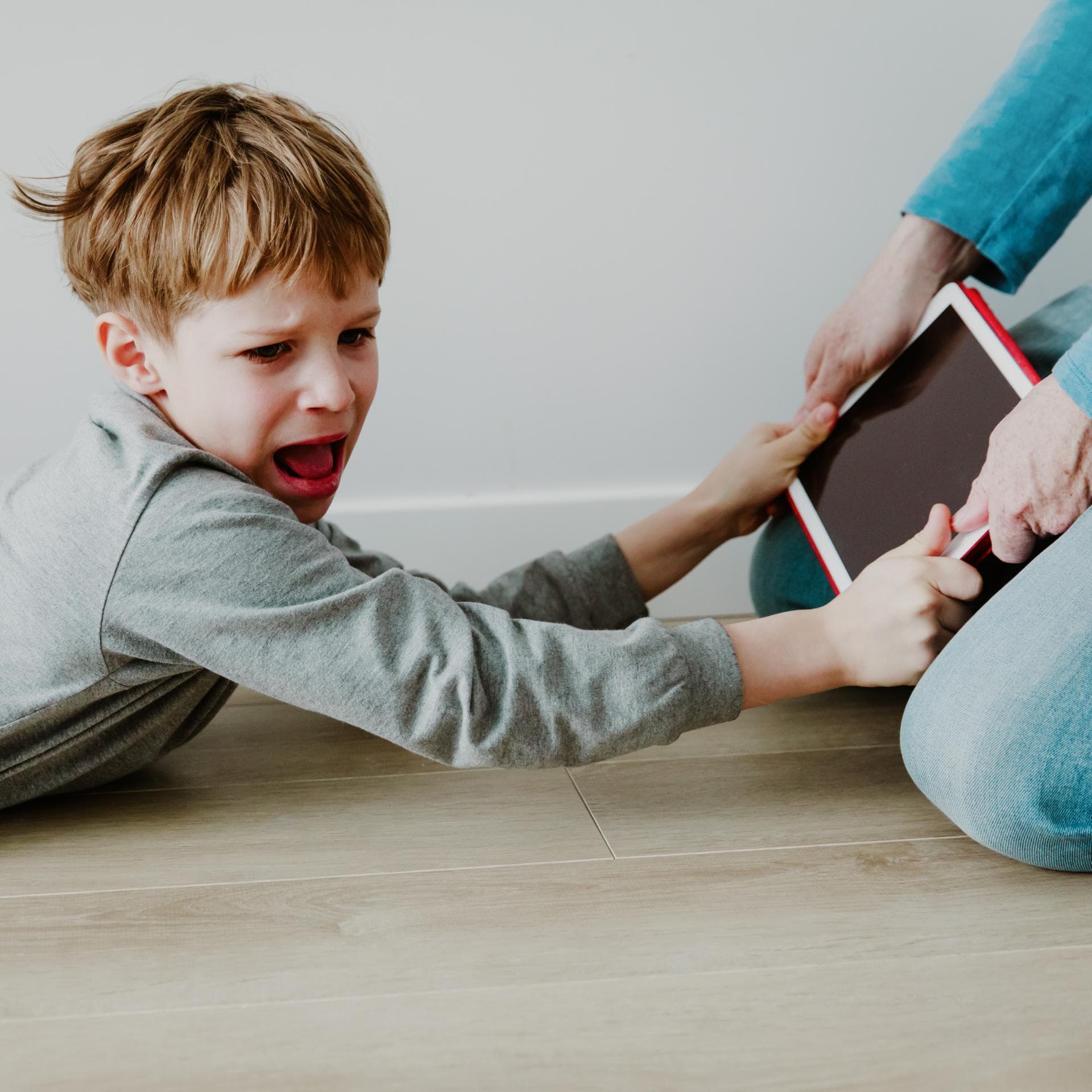 Junge hält schreiend das Tablet fest.