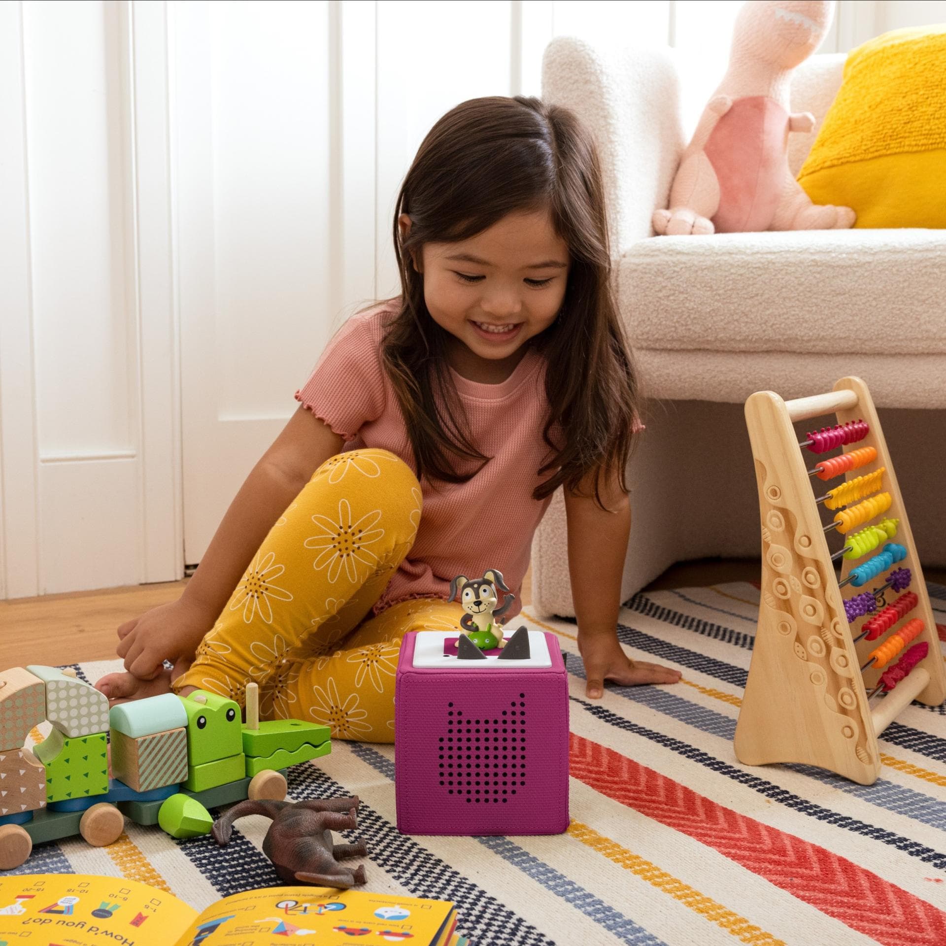 Mädchen sitzt neben der Toniebox.