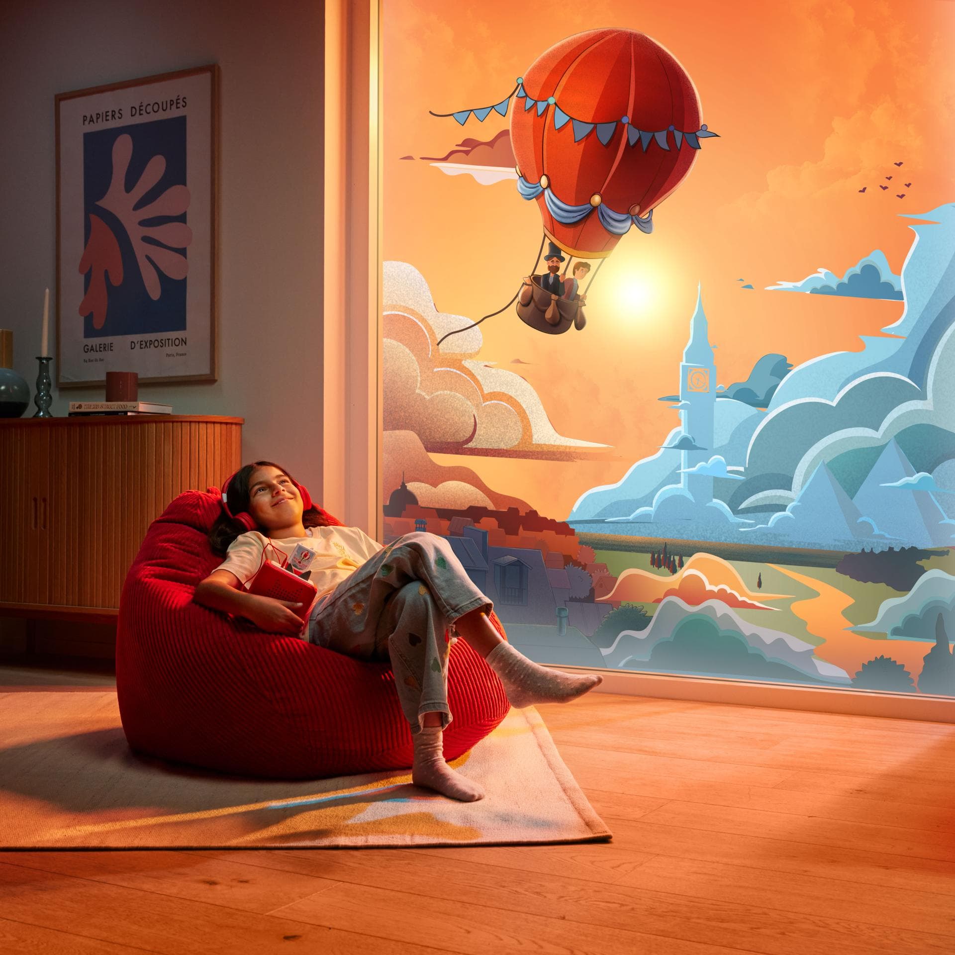 Kind träumt mit Hörbuch vor sich hin.