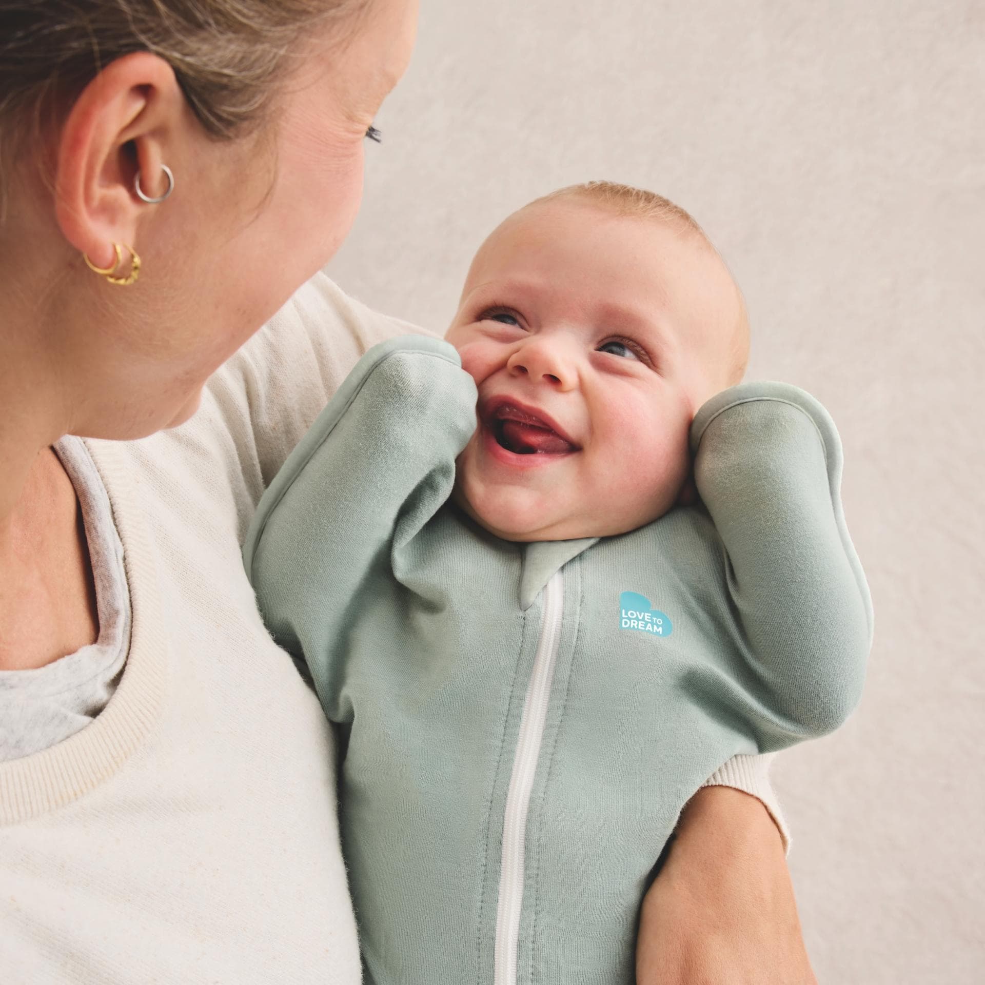 Baby im Pucksack auf Mamas Arm.