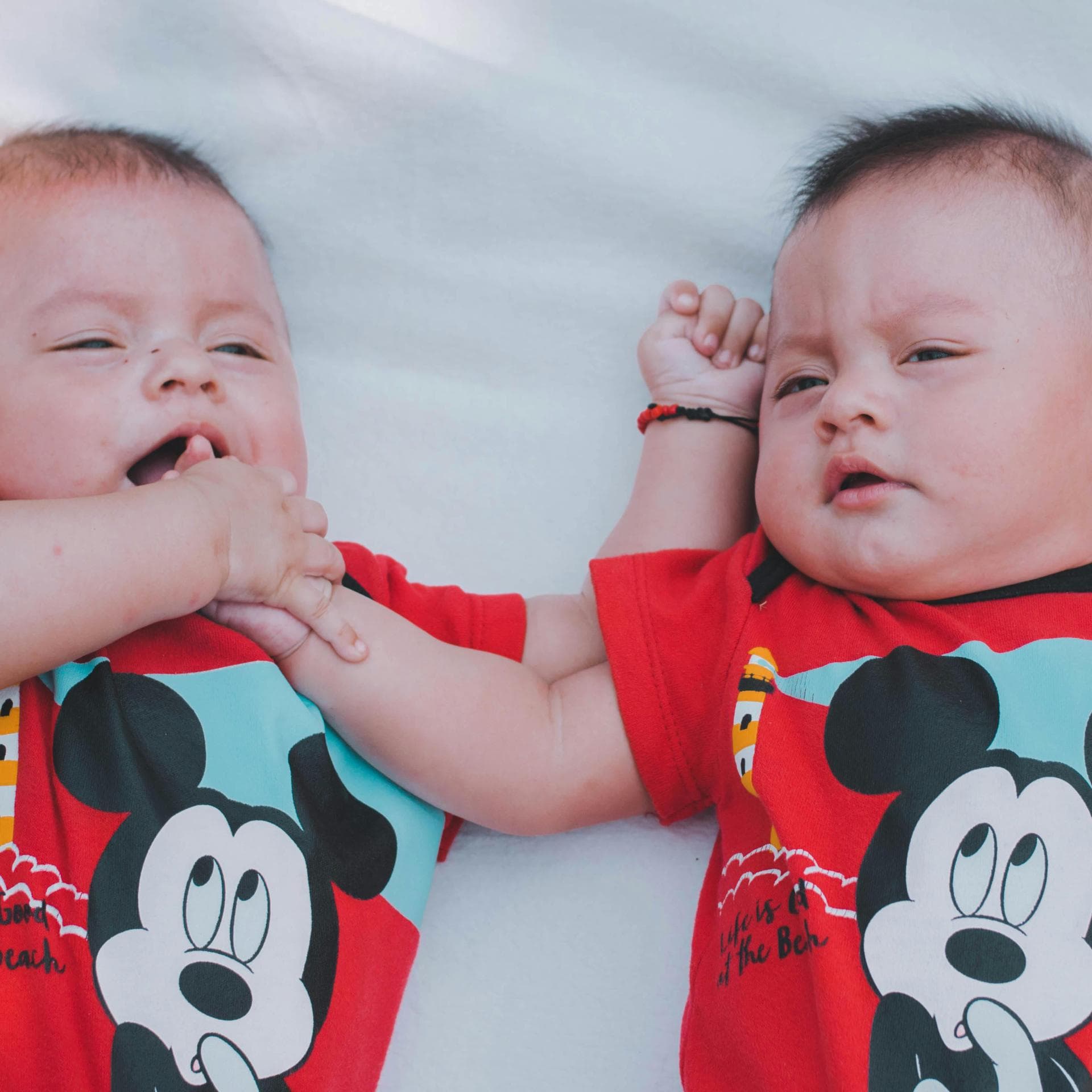 Zwillingsbabys mit Micky-Maus-Body