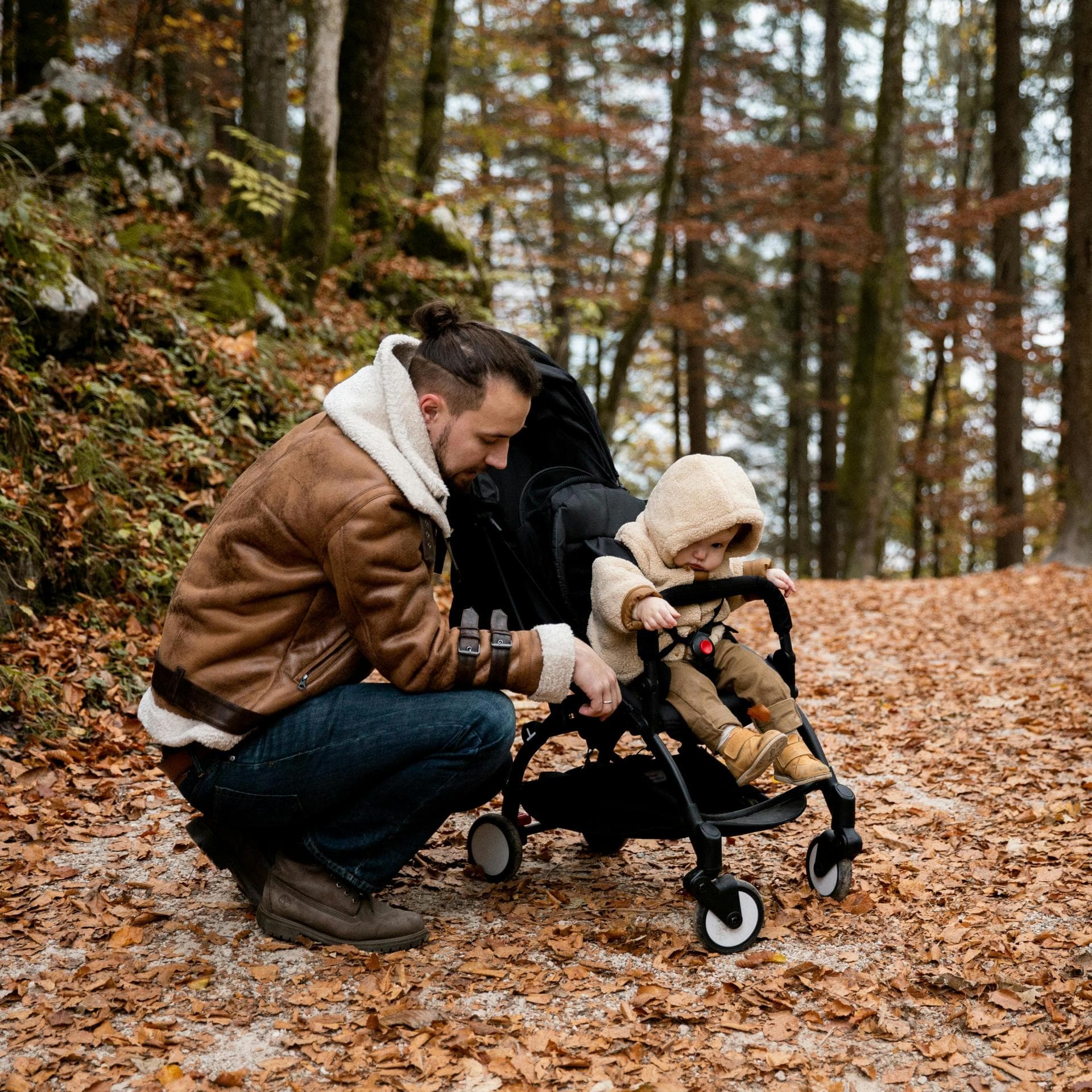 Vater mit Kind im Herbstwald.