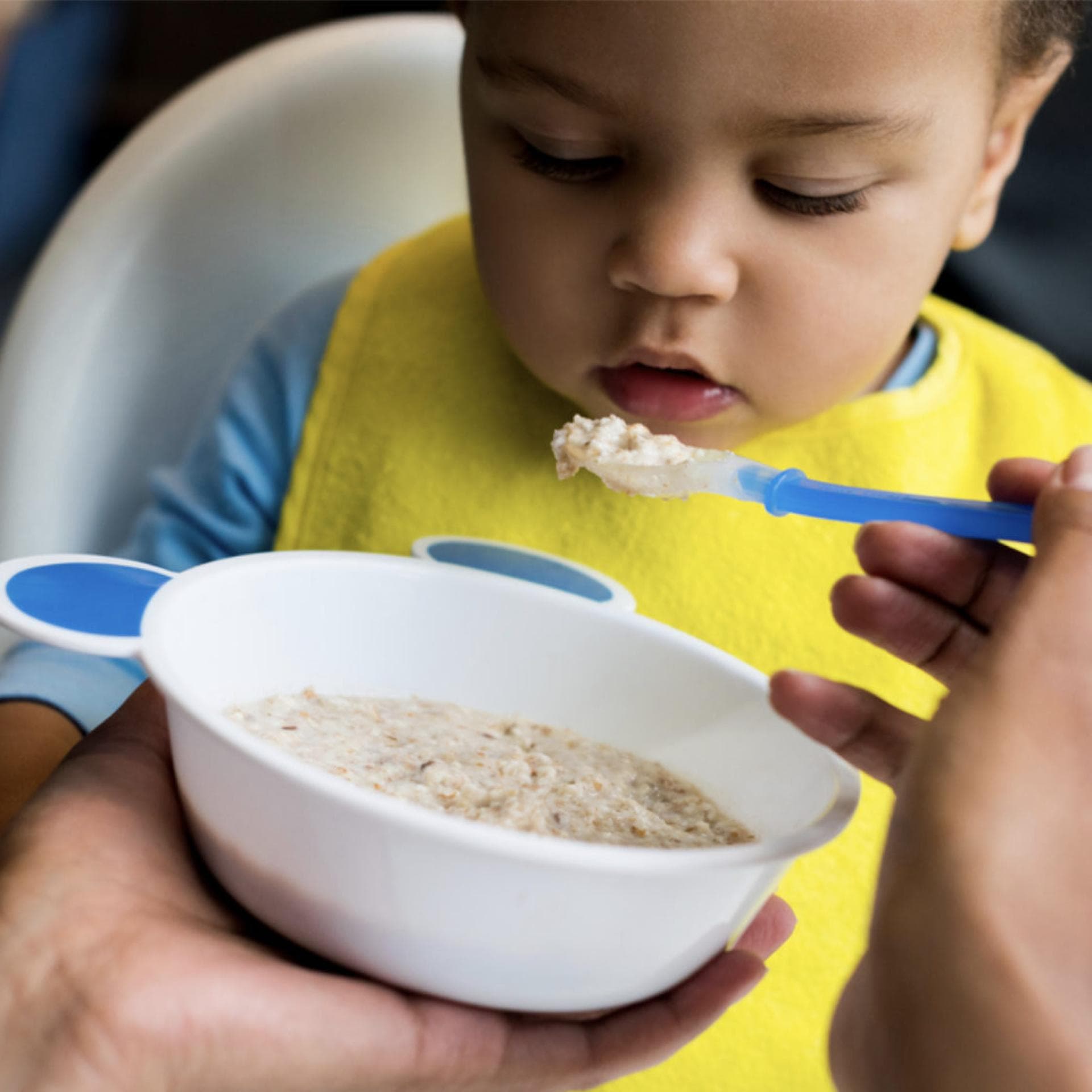Baby wird mit Getreidebrei gefüttert.