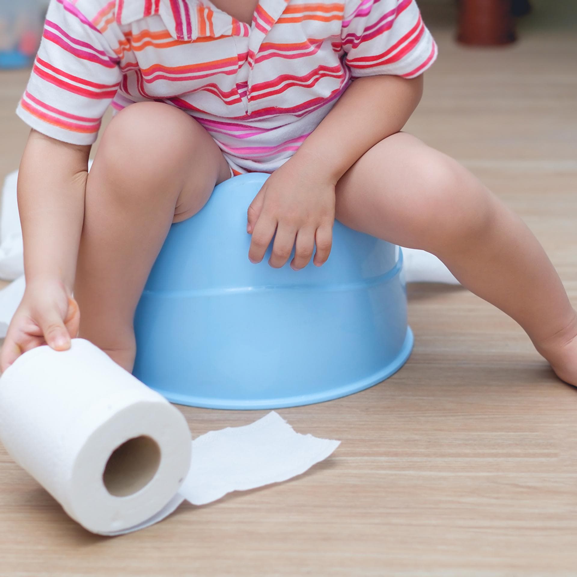 Ein kleines Kind sitzt auf einem Töpfchen.