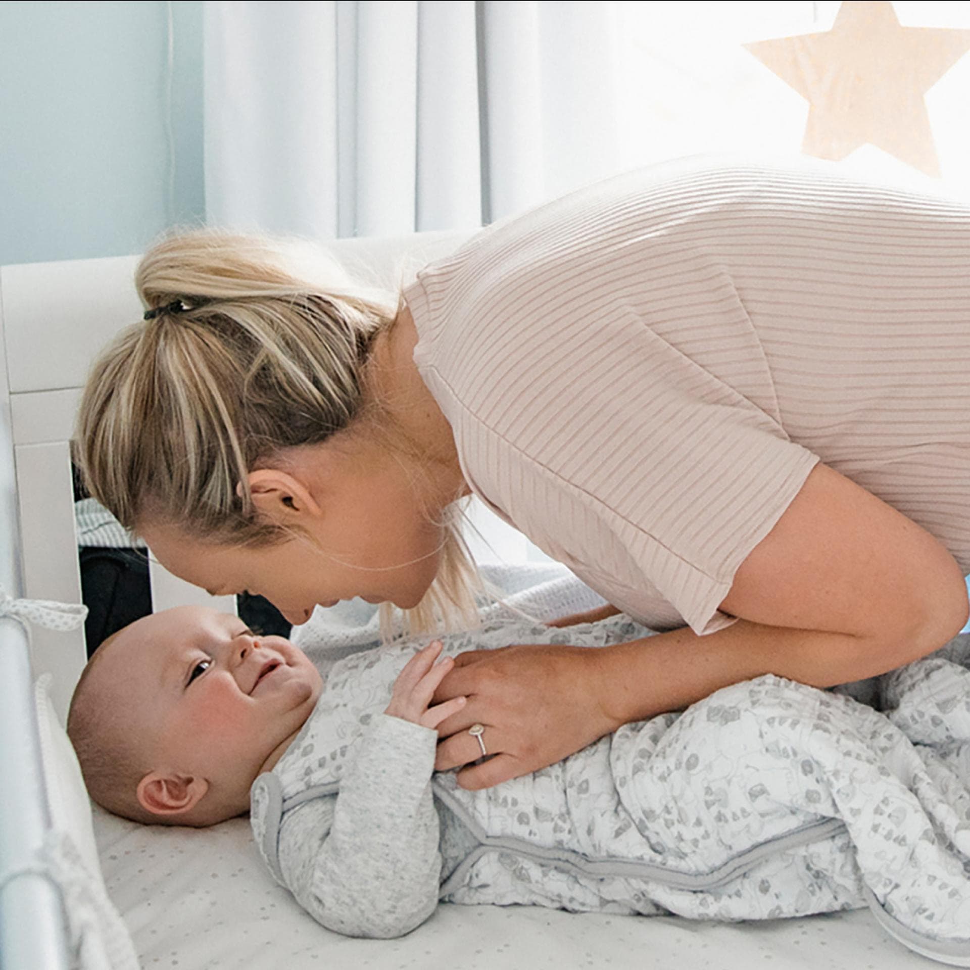 Eine Mama bringt ihr Baby ins Bett.