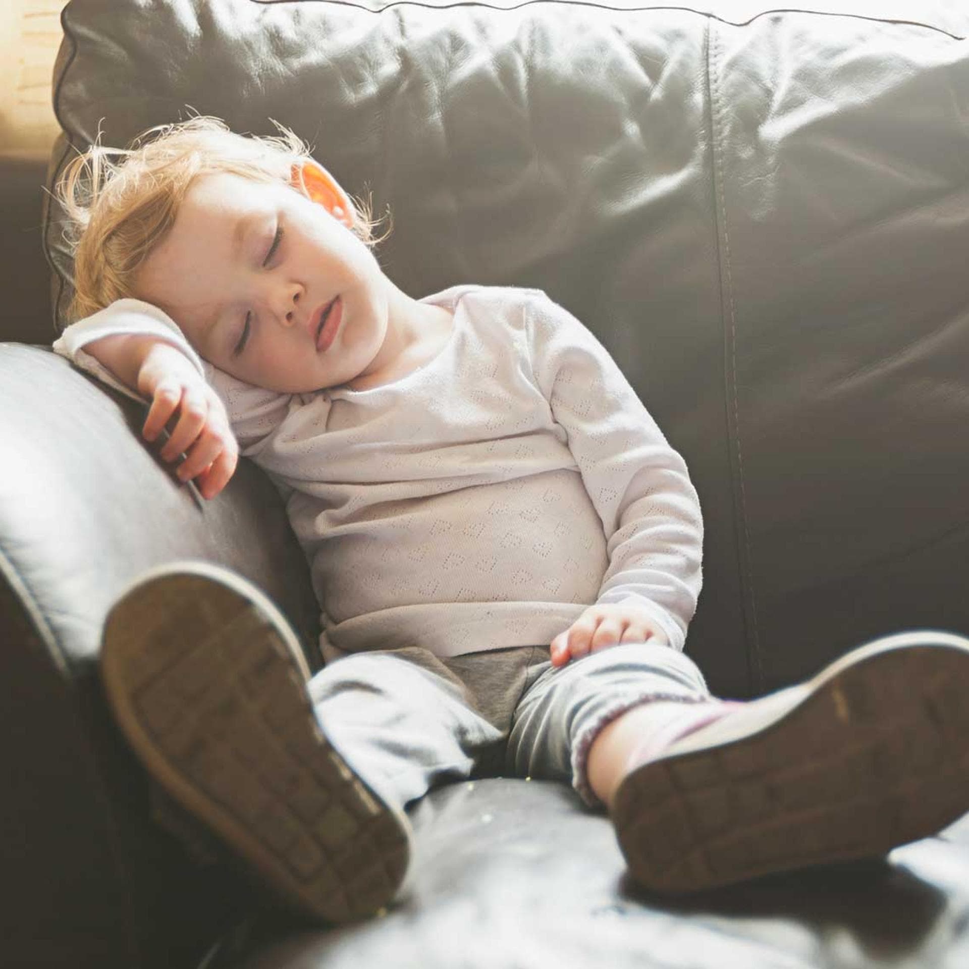 Ein Kleinkind, das auf dem Sofa einschläft.