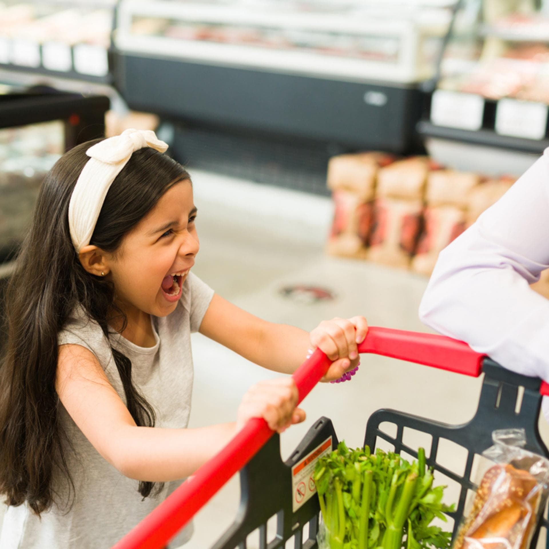 Kind schreit am Einkaufswagen.