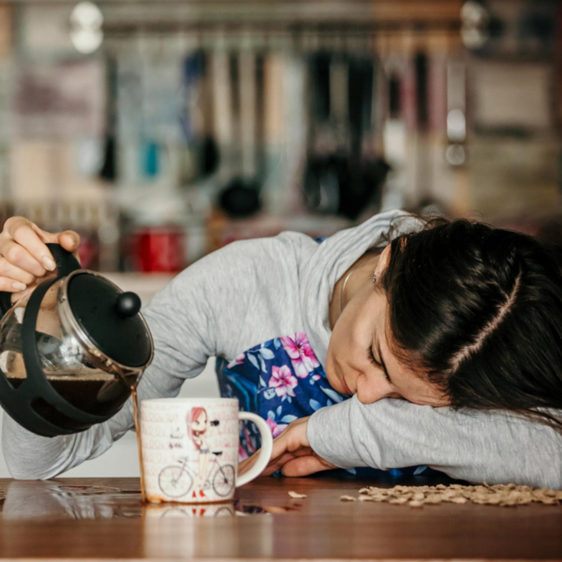 Müde Mama verschüttet Kaffee.