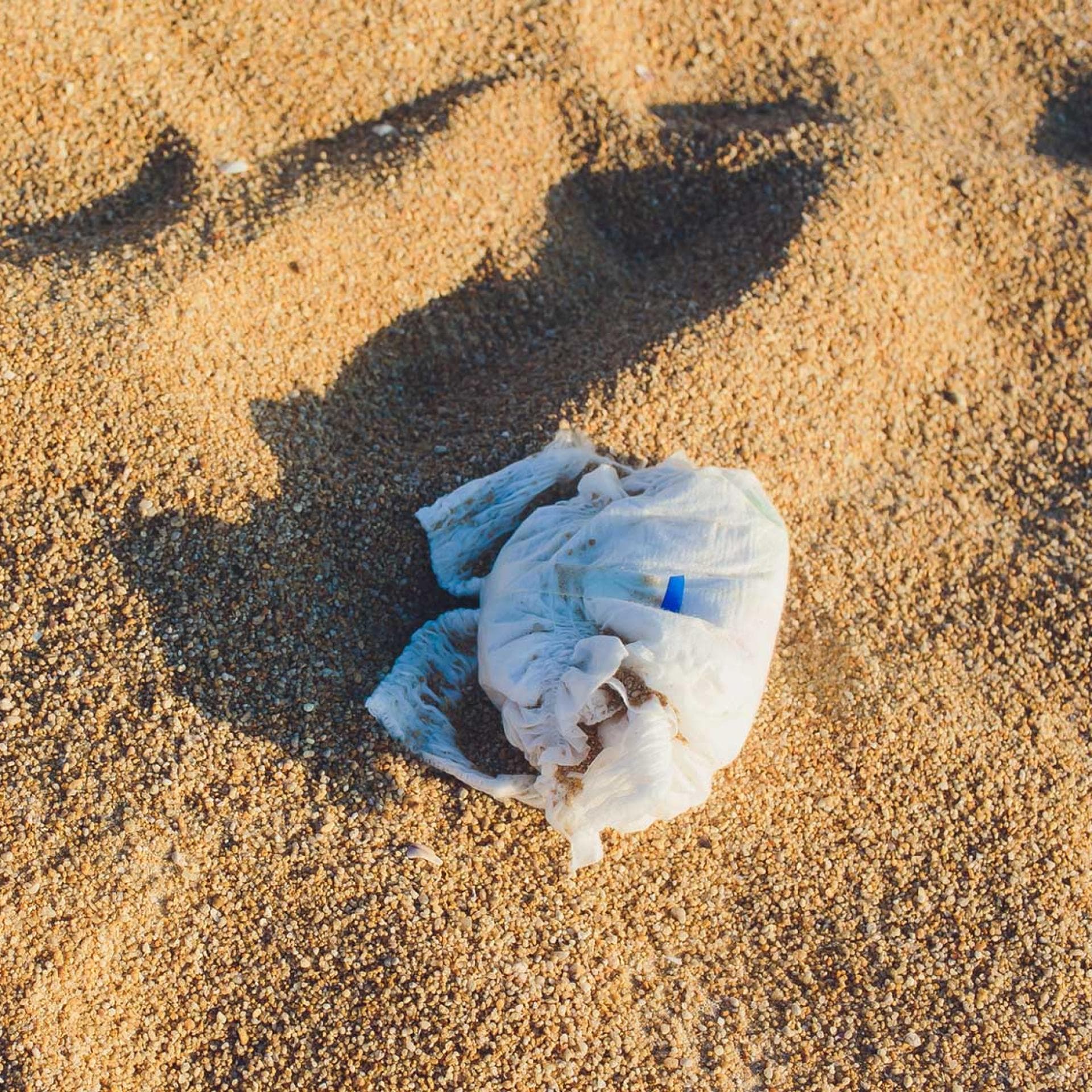 Eine dreckige Windel liegt am Strand