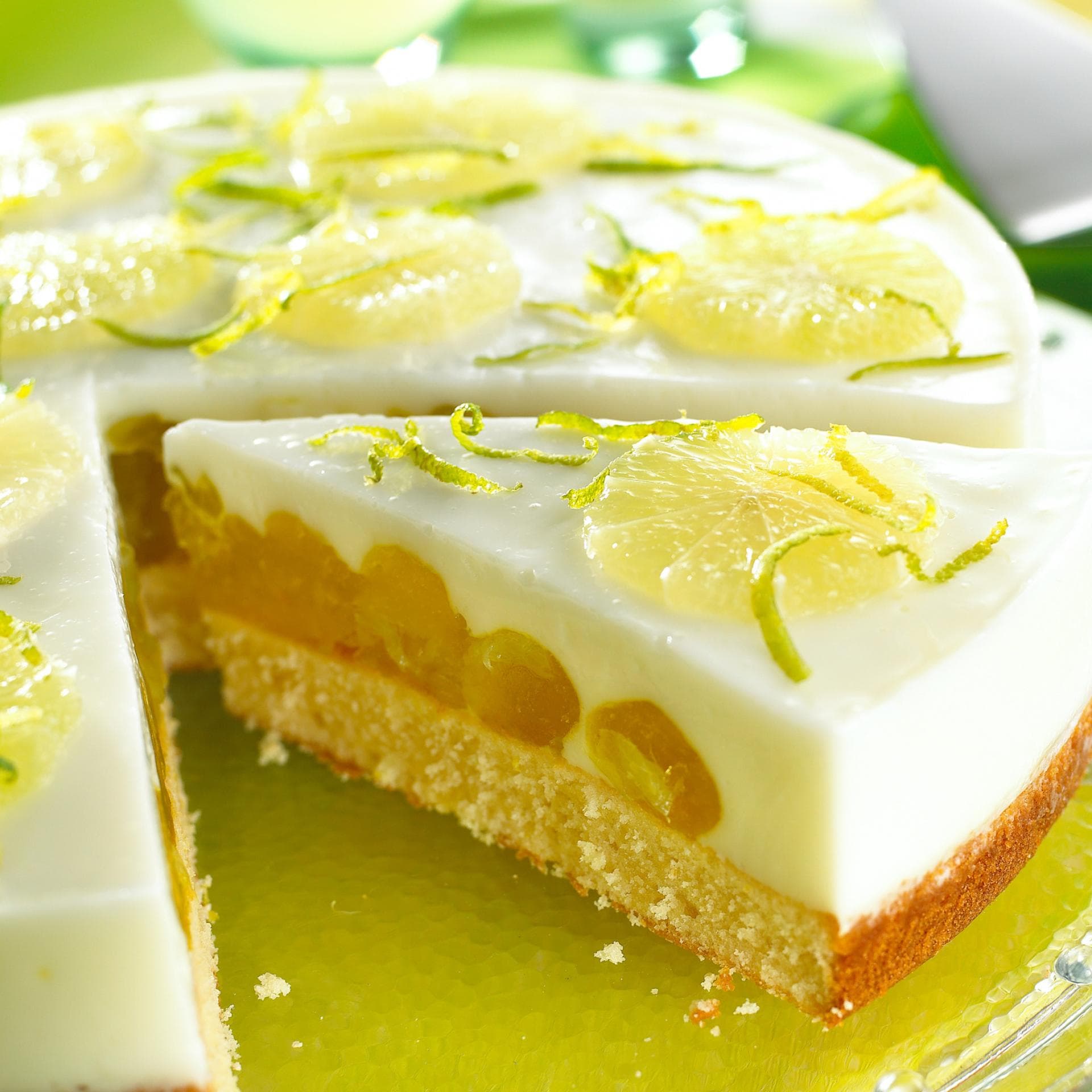Eine runde Fantatorte mit Limette liegt auf einer Kuchenplatte.
