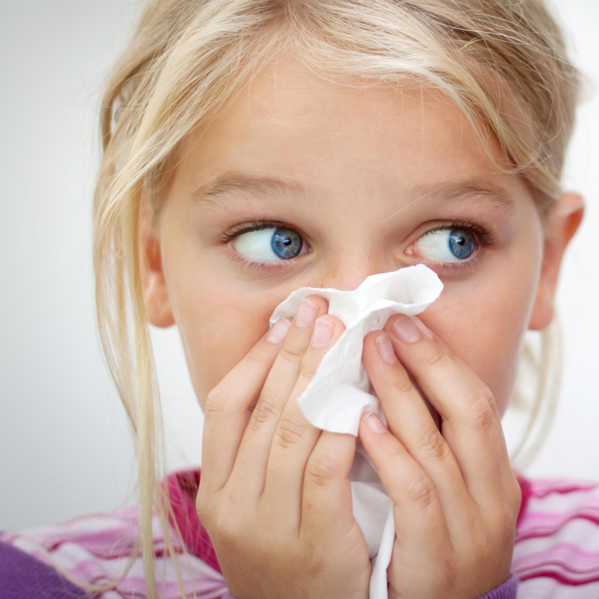 Mädchen putzt sich die Nase.