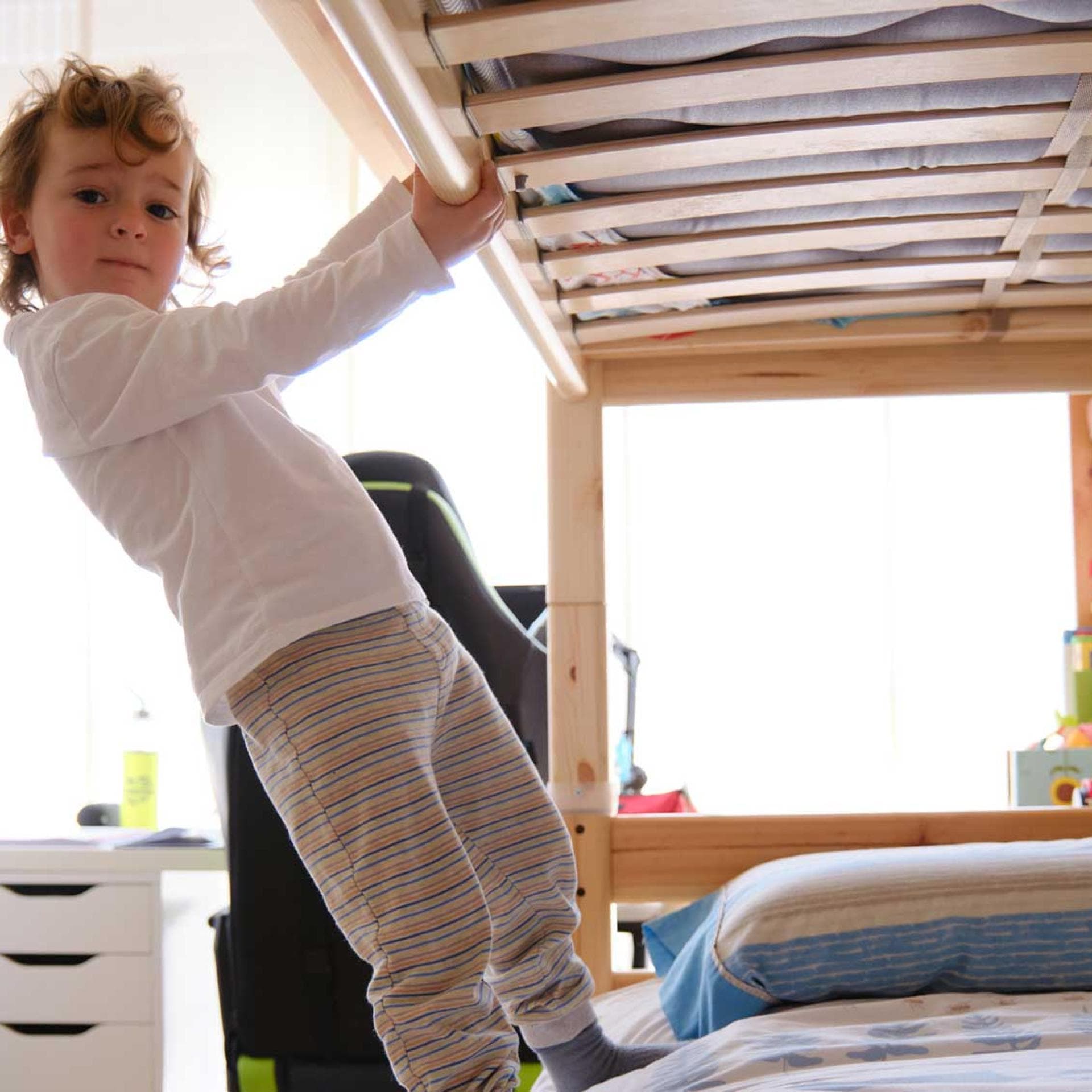 Kind steht unten auf Hochbett.