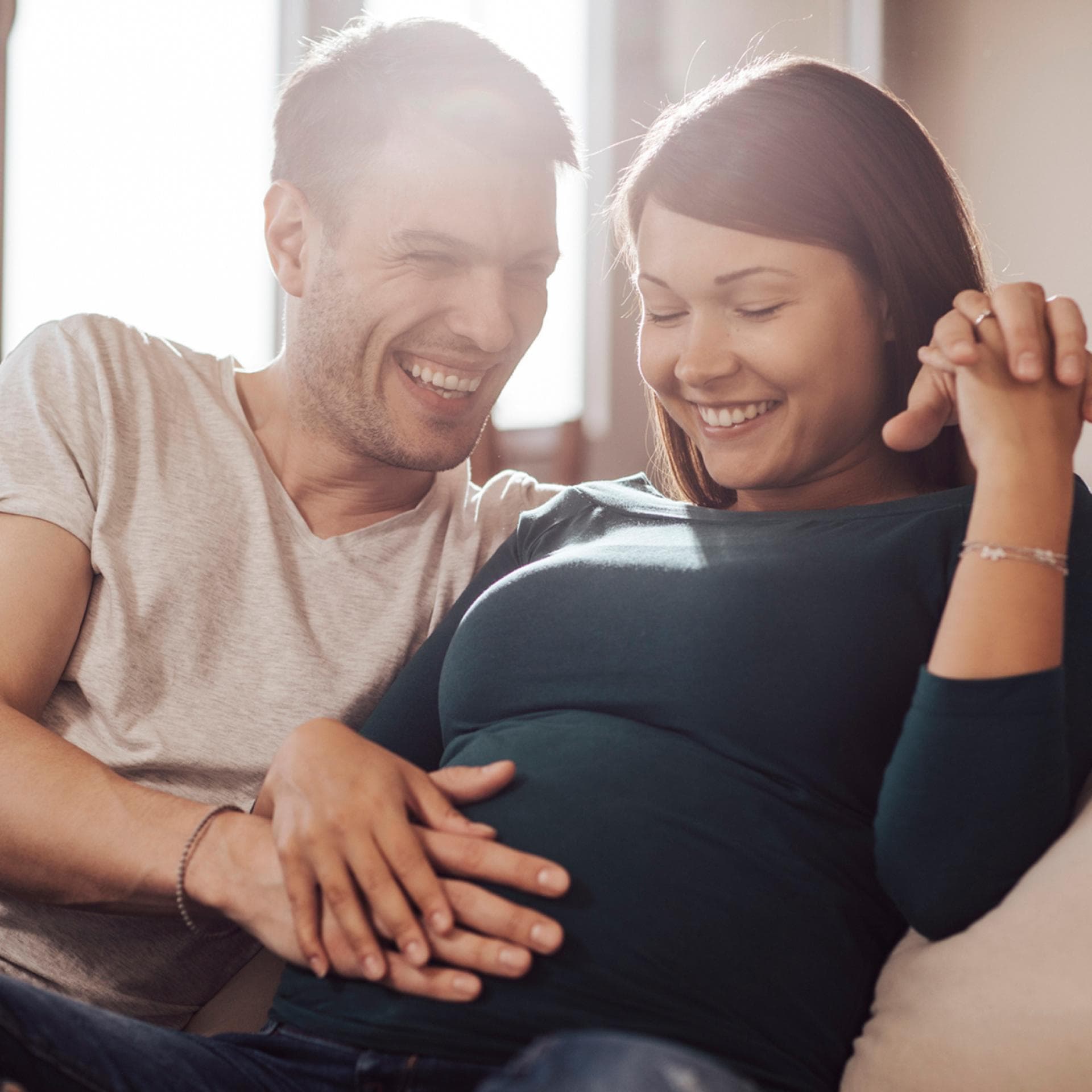 Paar streichelt den Babybauch.