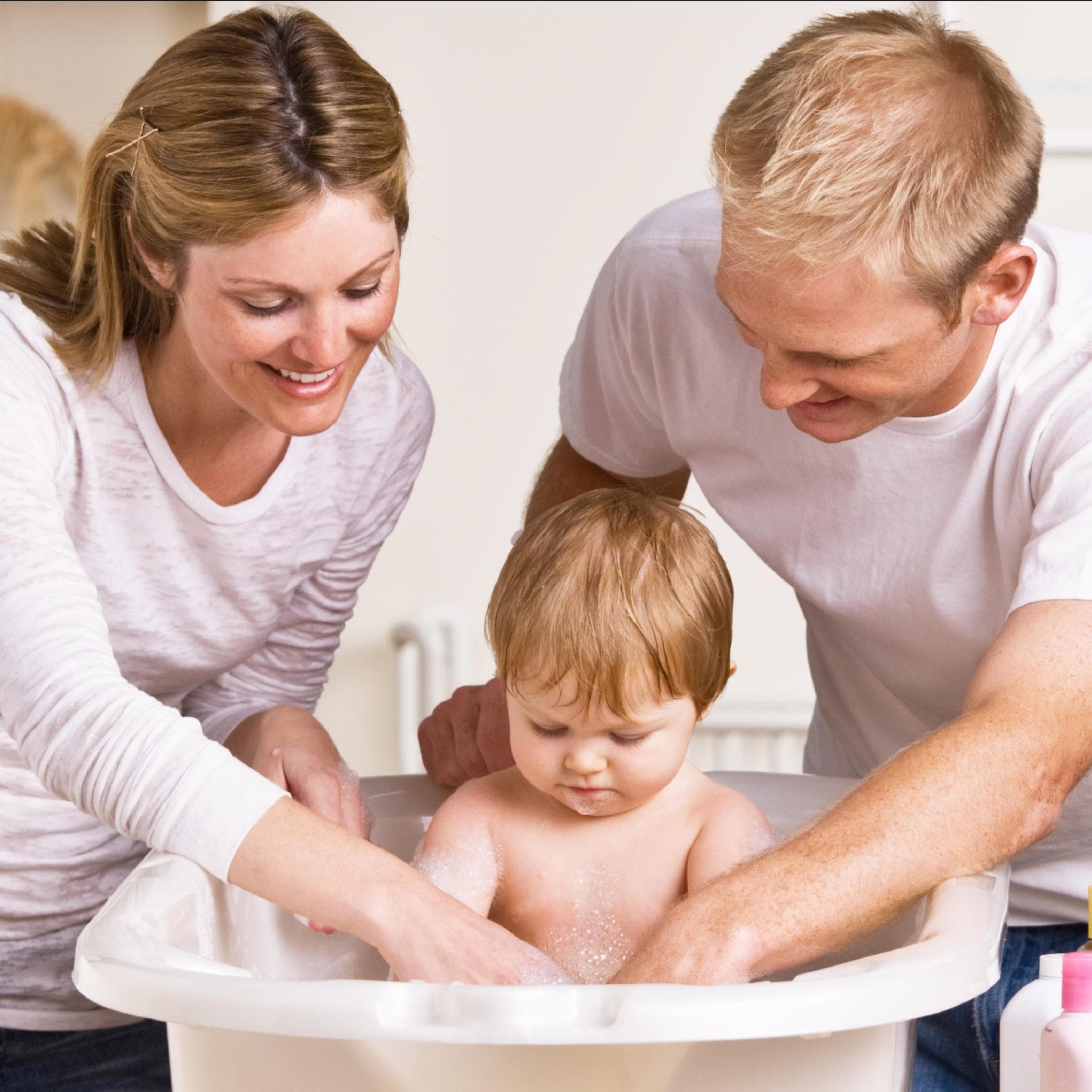 Eltern baden ihr Kleinkind.