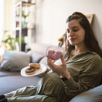 Eine Frau isst Donuts in der Schwangerschaft