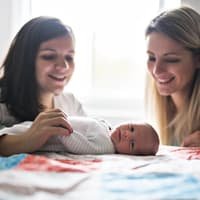 Ein Säugling und zwei Frauen