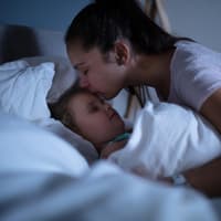 Mutter tröstet ihr Kind nach einem Nachtschreck