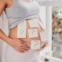Babybauch mit Fragezeichen beklebt