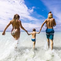 Eine Familie läuft ins Meer.